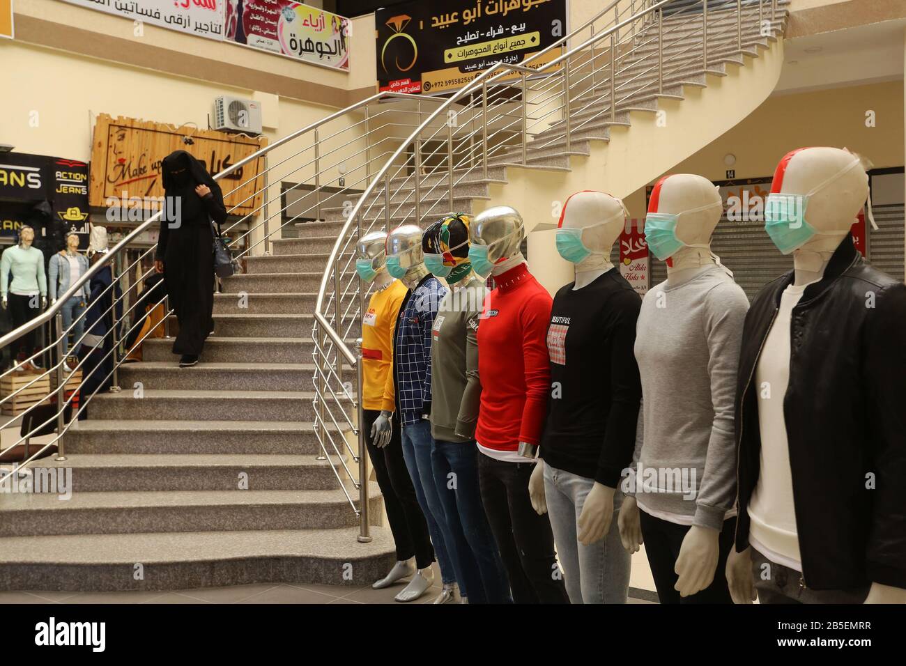 El 8 de marzo de 2020, se exhibió maniquíes con máscaras faciales fuera de una tienda de ropa, en la Franja de Gaza, para difundir la conciencia sobre la enfermedad coronavirus COVID-19, Foto de stock