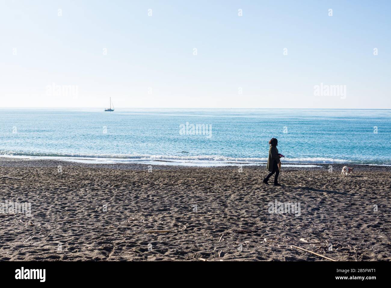 Cecina, Toscana, Italia - 2020 de enero: Invierno escena costera en Toscana con la gente que disfruta del soleado clima italiano en una playa de arena Foto de stock