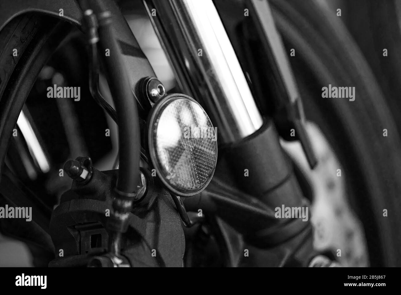 Primer plano de los frenos de la motocicleta y de la rueda delantera. Blanco y negro. Foto de stock
