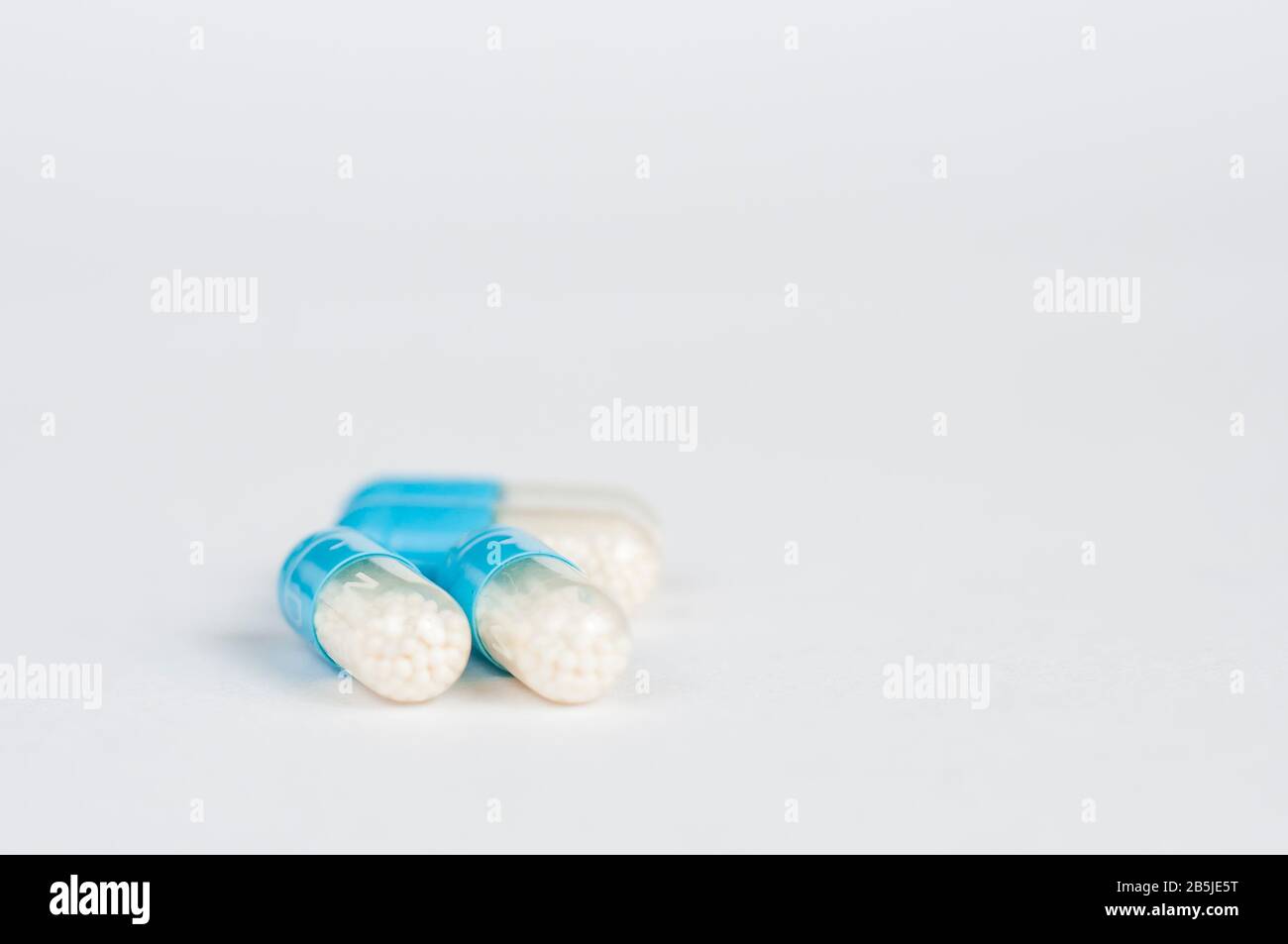 Pastillas de cápsula de antibióticos de color azul-blanco. Antecedentes de farmacia. Resistencia a los antimicrobianos. Industria farmacéutica. Asistencia sanitaria global. Foto de stock