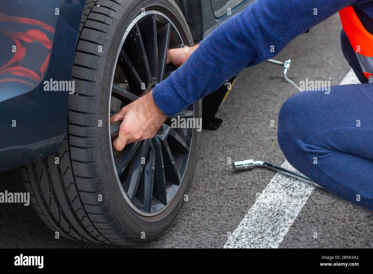 Tornillos técnico una rueda del coche con neumáticos de invierno llave  dinamométrica afuera durante la estación de sustitución de neumáticos  Fotografía de stock - Alamy
