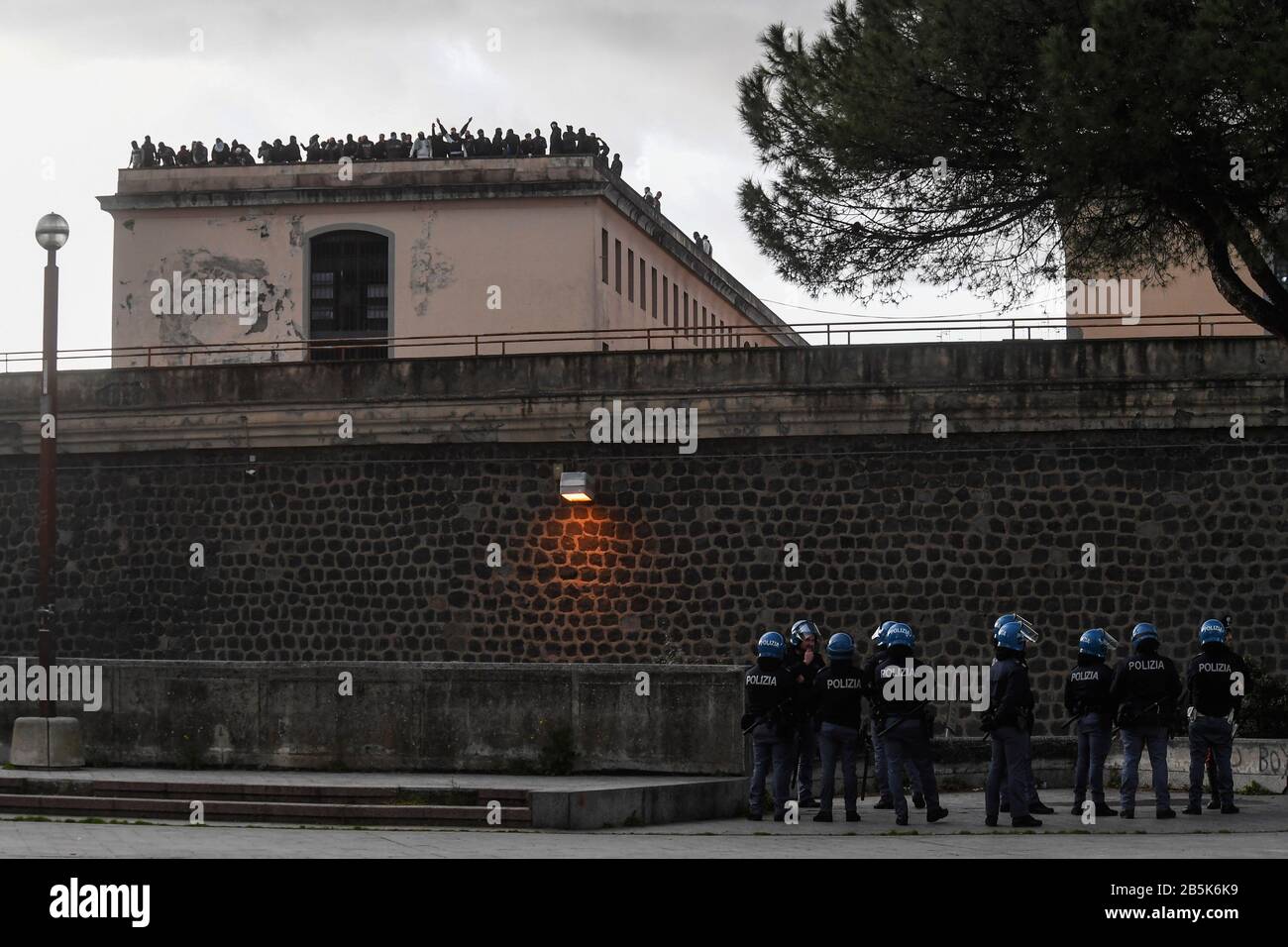 Nápoles momentos de tensión fuera de los muros de la prisión entre la policía y los familiares de los detenidos que ocupan y suben los tejados de los pabellones internamente para protestar por la disposición del gobierno de suspender las visitas hasta mayo y por presuntos casos de virus Coronavid COVID 19 en la misma prisión. 08-03-2020 Nápoles. Foto de stock