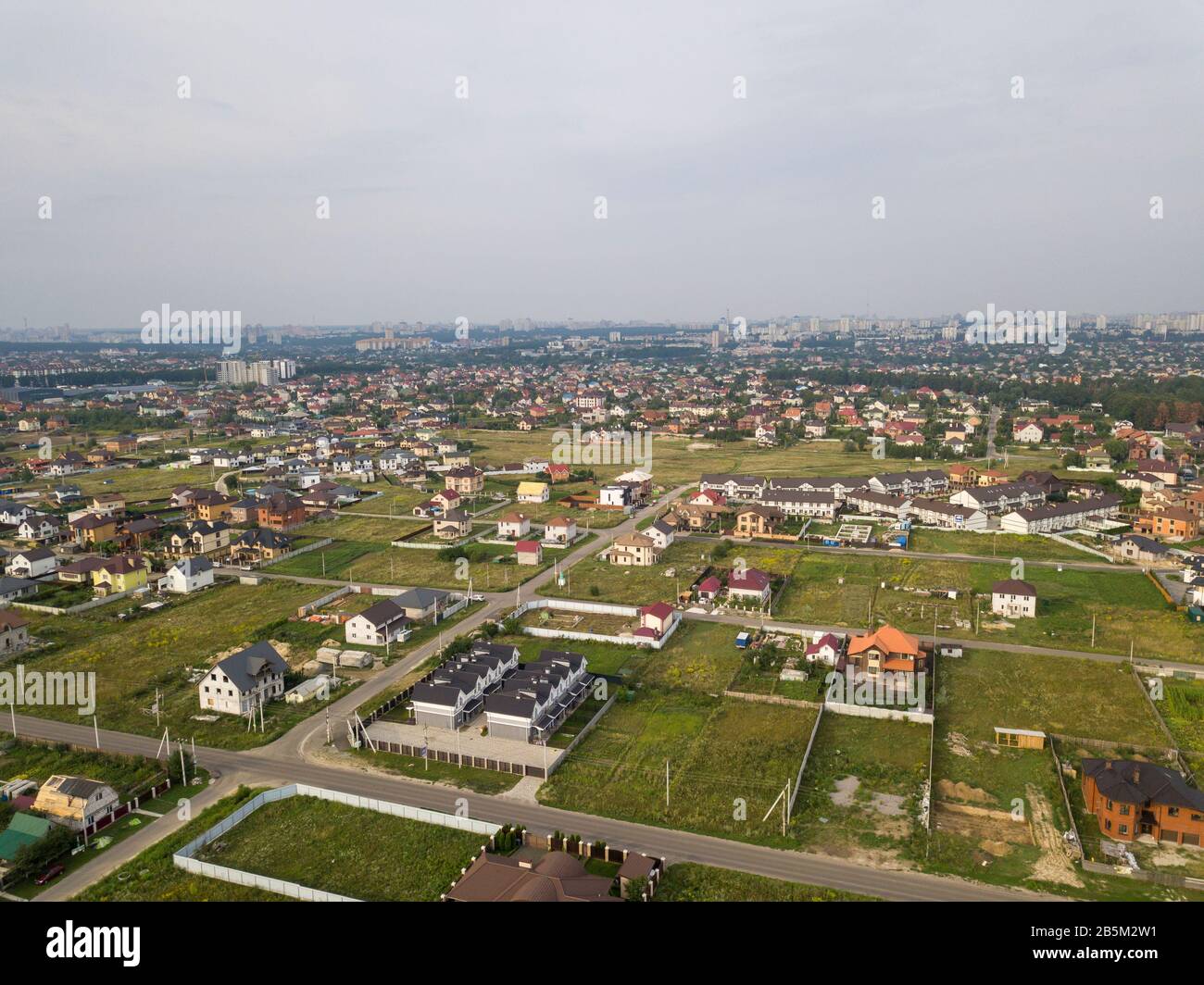 Vista aérea de la aldea sobre el fondo de la ciudad en un día de verano Foto de stock