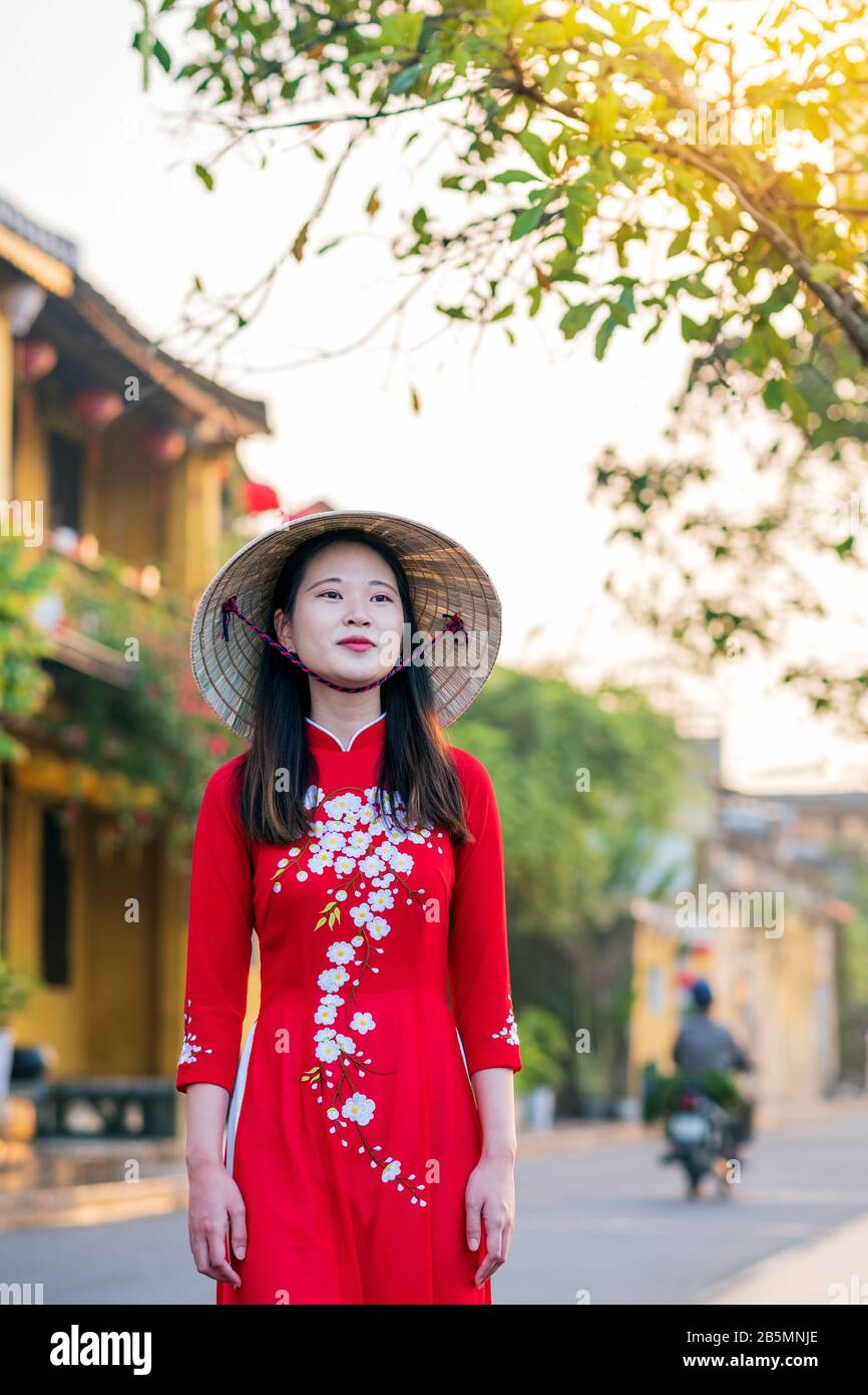 Una joven vietnamita que viste un vestido tradicional de Ao Dai en las calles de la vieja Hoi An Foto de stock