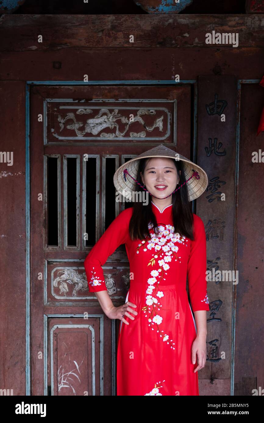 Una joven vietnamita que viste un vestido tradicional de Ao Dai en las calles de la vieja Hoi An Foto de stock