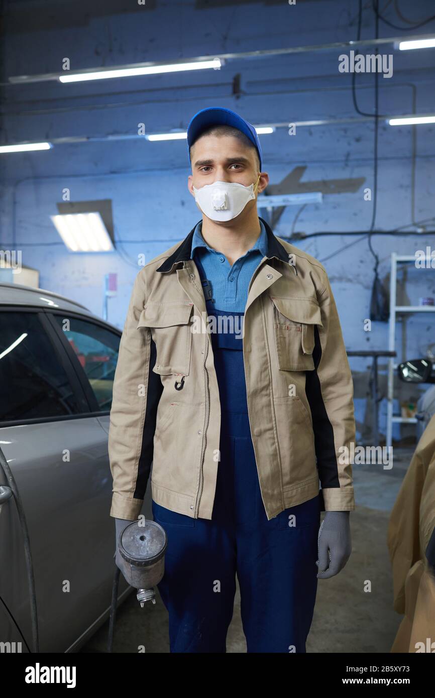 Retrato vertical de medio largo del pintor profesional de coches con ropa  de trabajo protectora y máscara en la cara mirando a la cámara Fotografía  de stock - Alamy