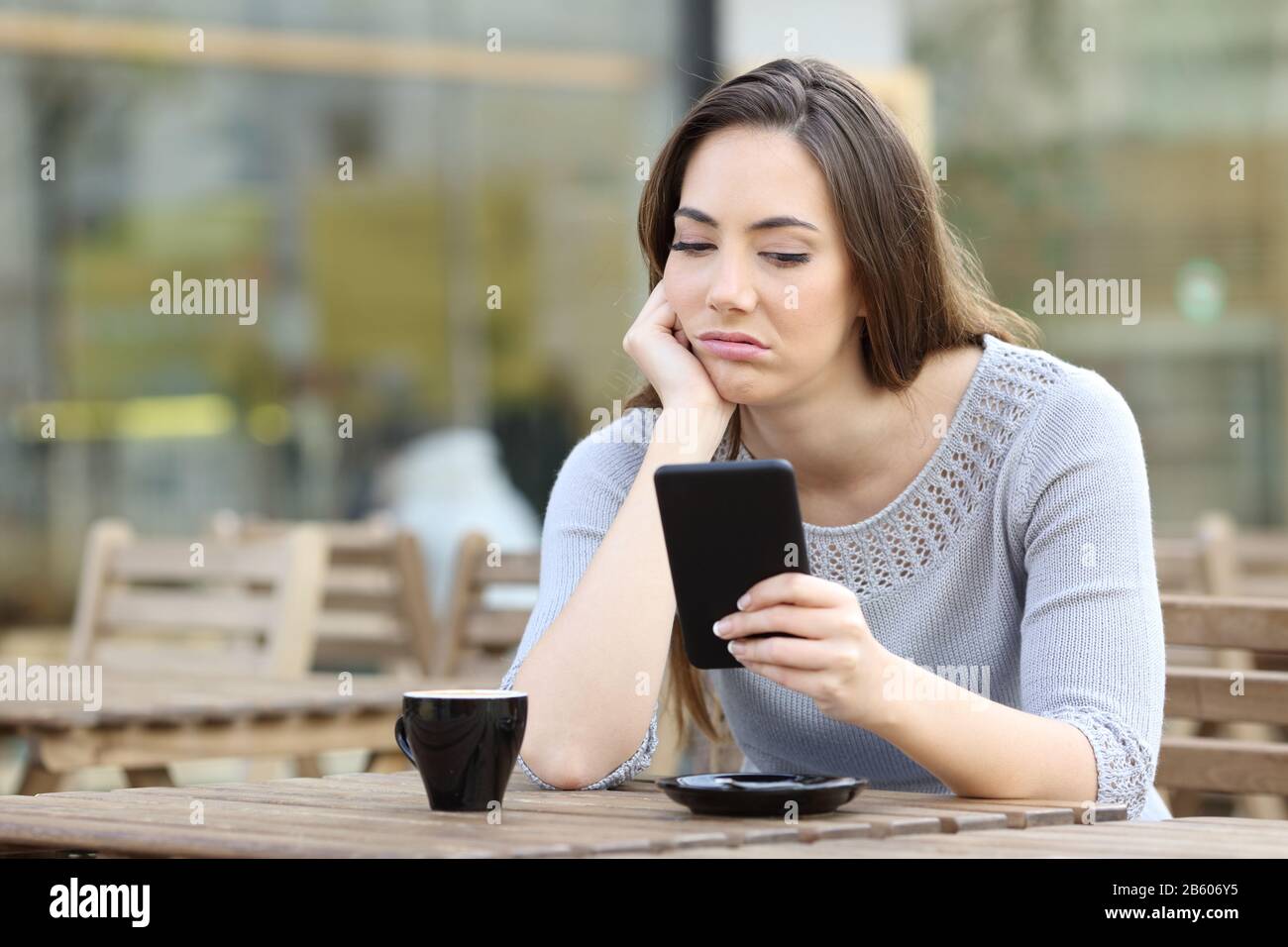 Una chica aburrida que parecía decepcionada por su teléfono inteligente
