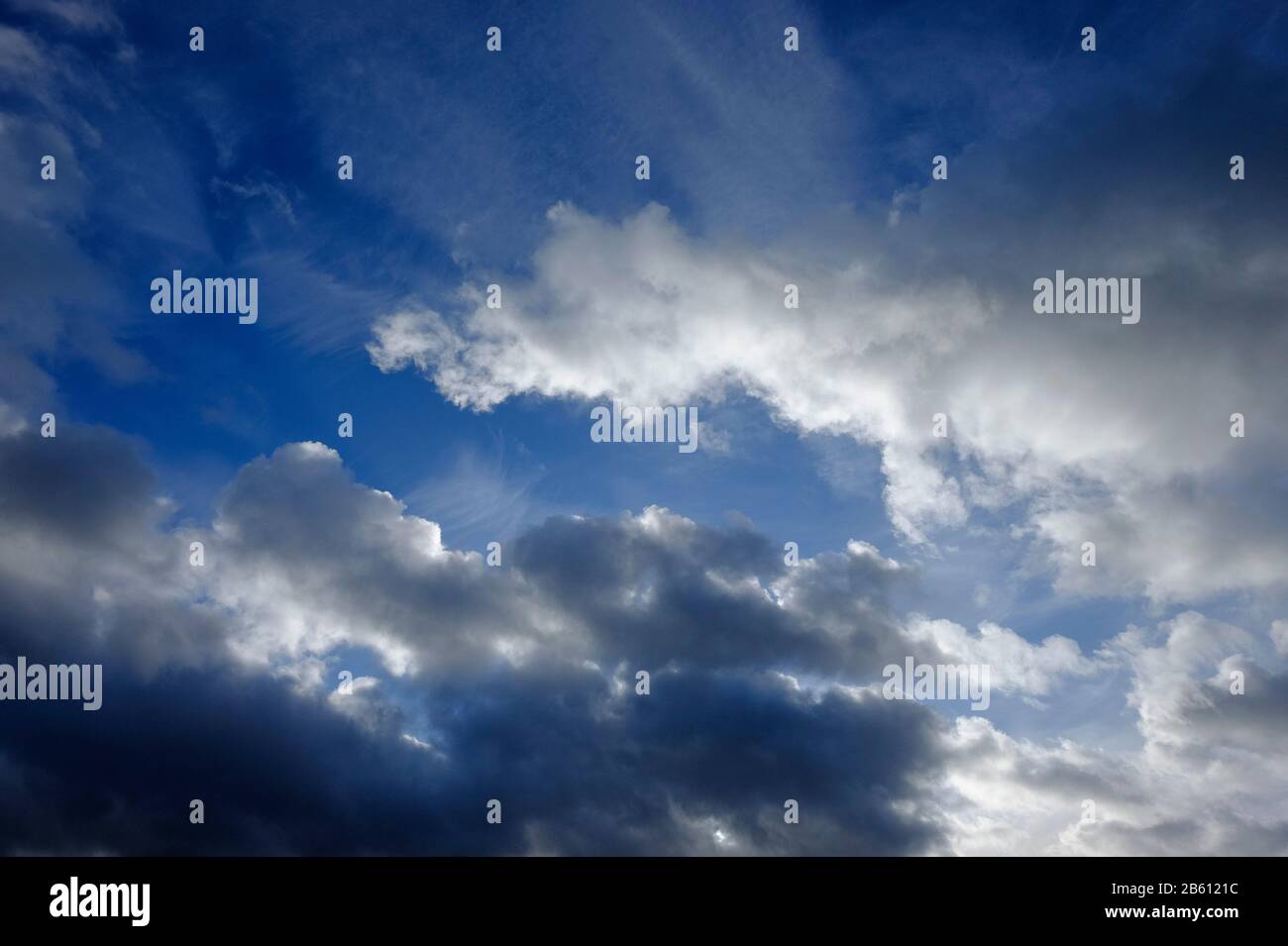 luz solar retroiluminada a través del cielo azul nublado Foto de stock