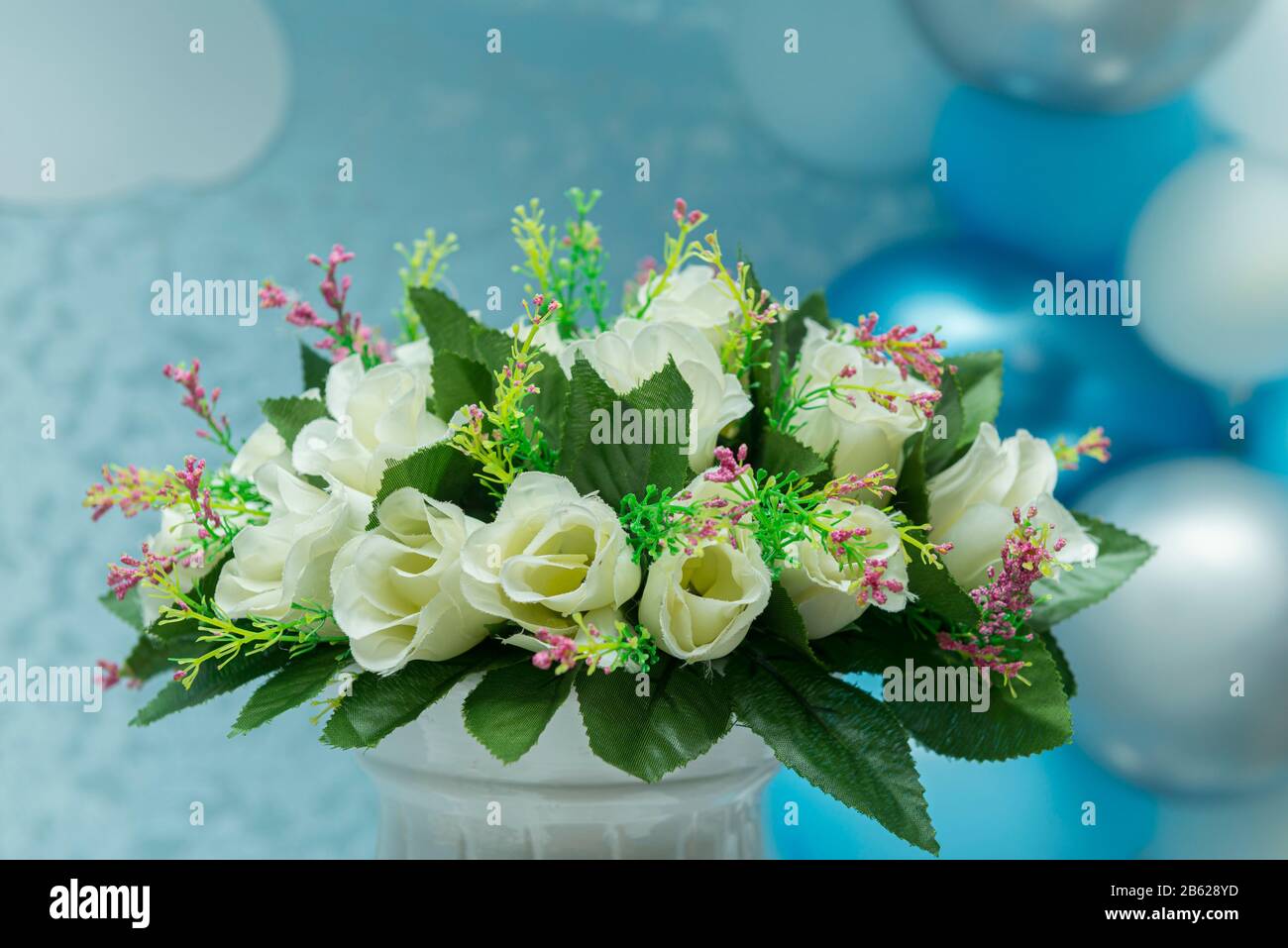 Hermoso ramo de rosas blancas con fondo difuminado de globos 