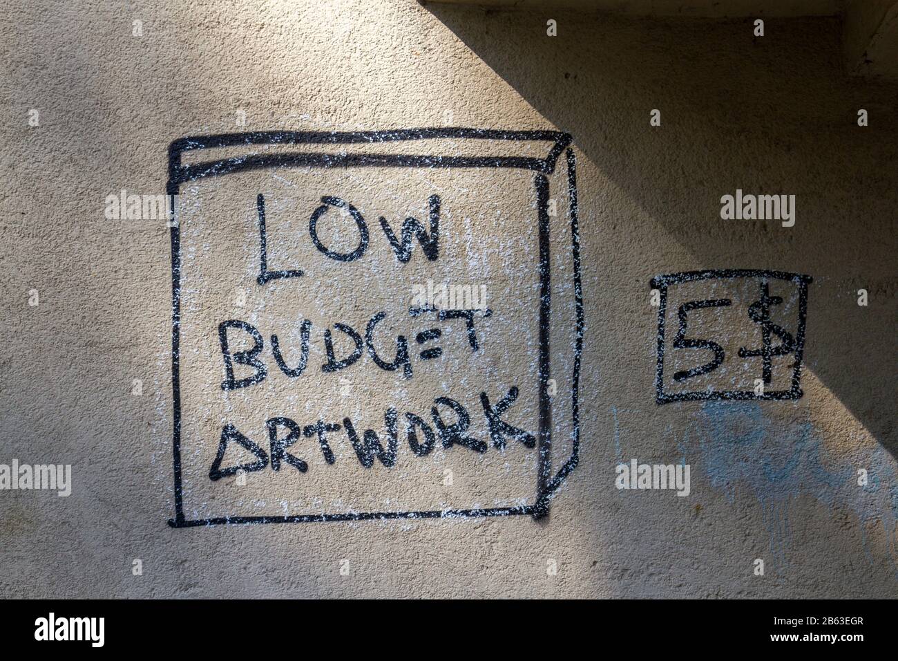 Divertido 'Low Budget Artwork - $5' pintado en una pared en Amberg, Baviera, Alemania. Foto de stock