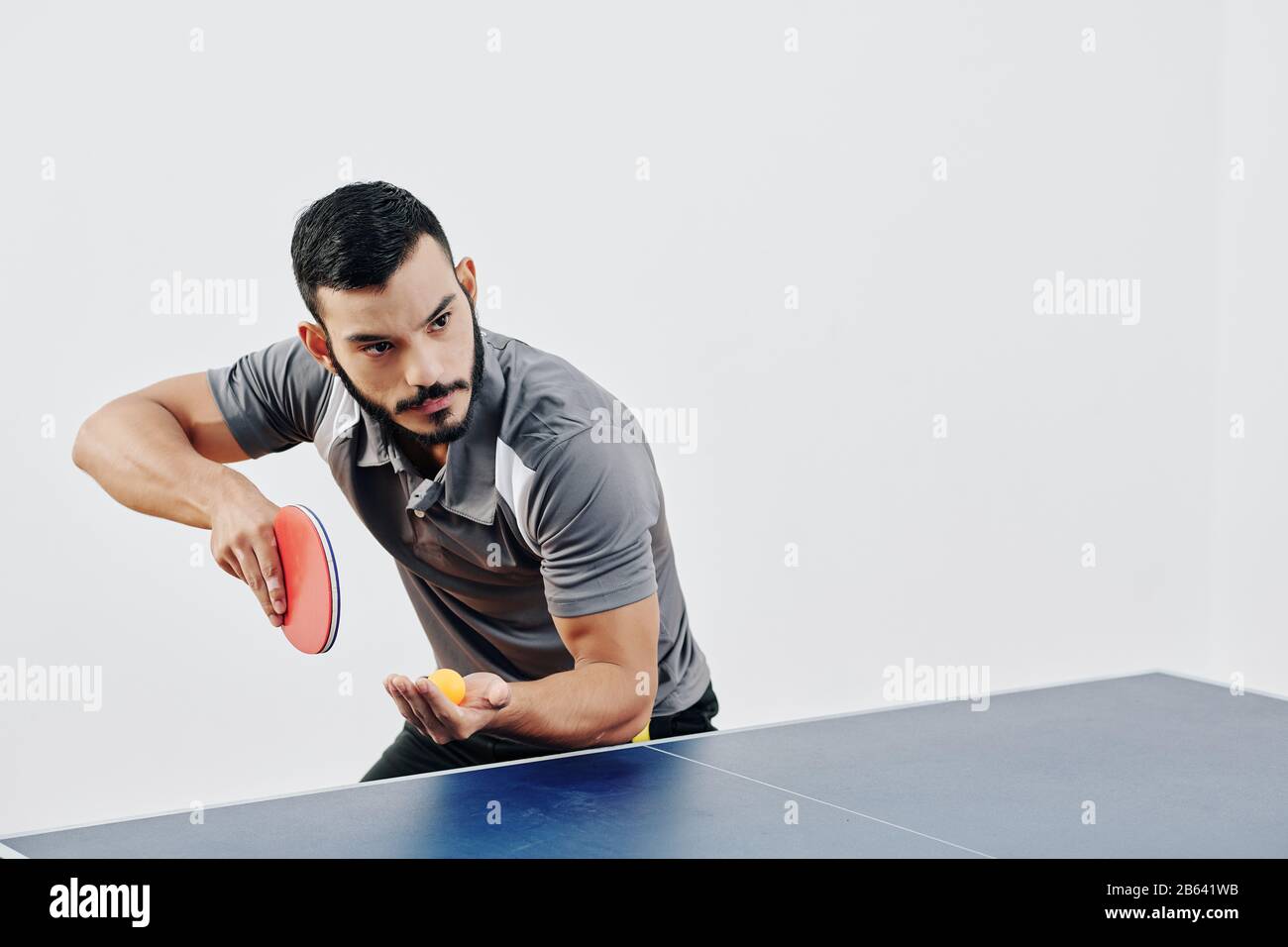 Jugador profesional de tenis de mesa de pie en cierta posición para servir  a la pelota y comenzar el juego Fotografía de stock - Alamy