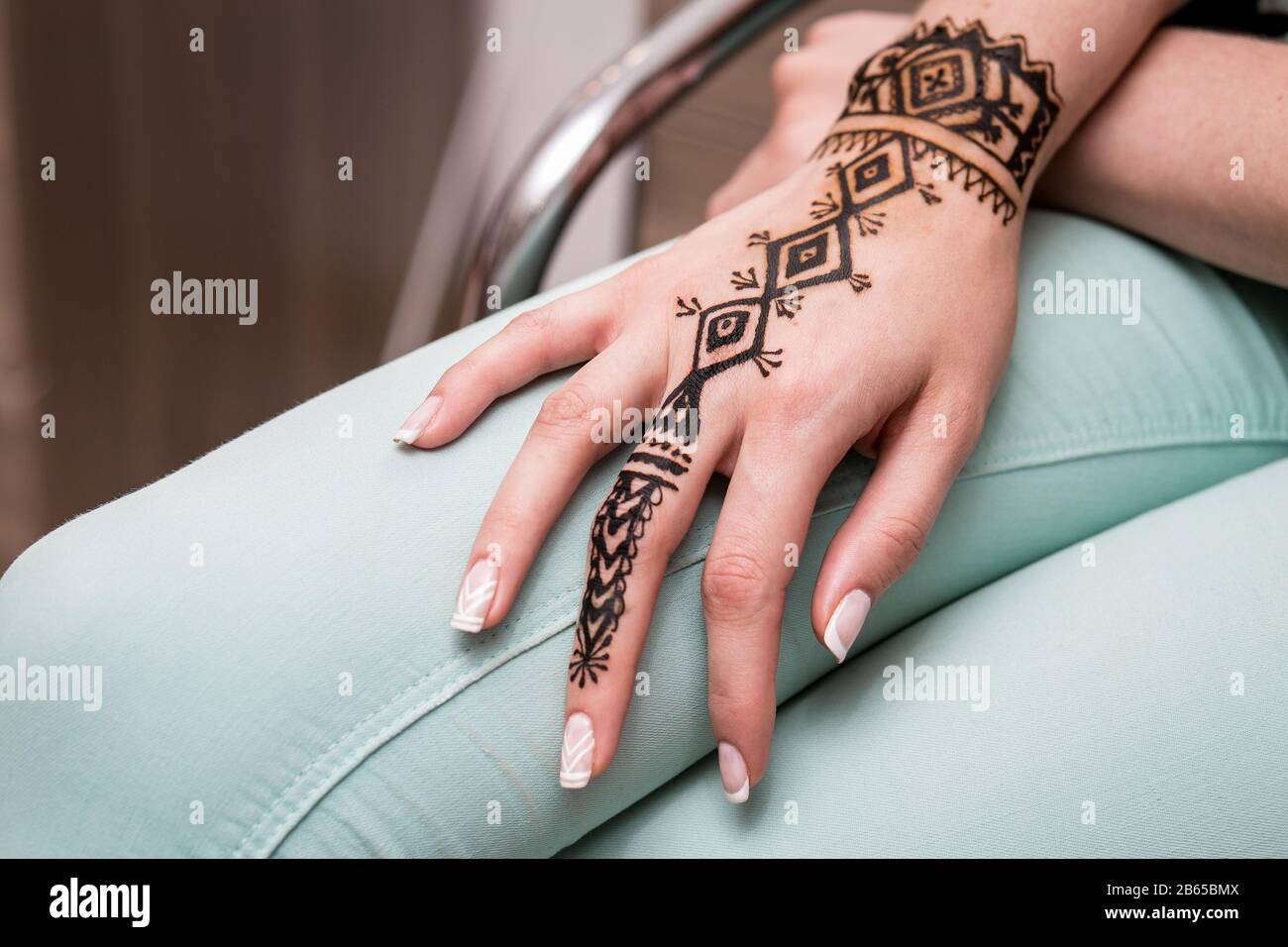 Pintado a mano con henna en una pierna de mujer en el salón Fotografía de  stock - Alamy