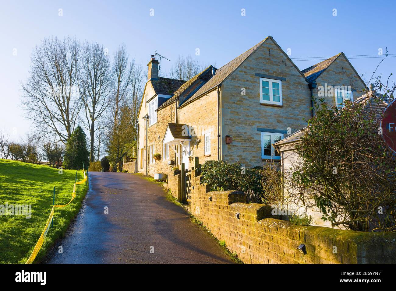 Se acerca a la cumbre de Nocketts Hill cerca de Chippenham, donde las antiguas casas rurales se han convertido en cómodas viviendas en Wiltshire, Inglaterra, Reino Unido Foto de stock