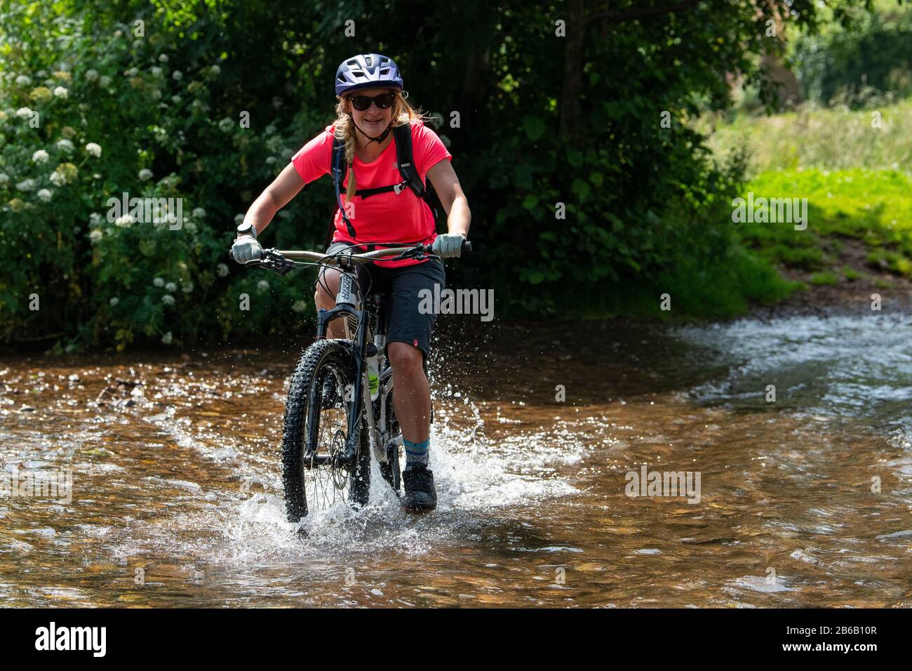 Una joven rubia recorre una bicicleta de montaña por un arroyo cerca de  Minehead en Somerset Fotografía de stock - Alamy