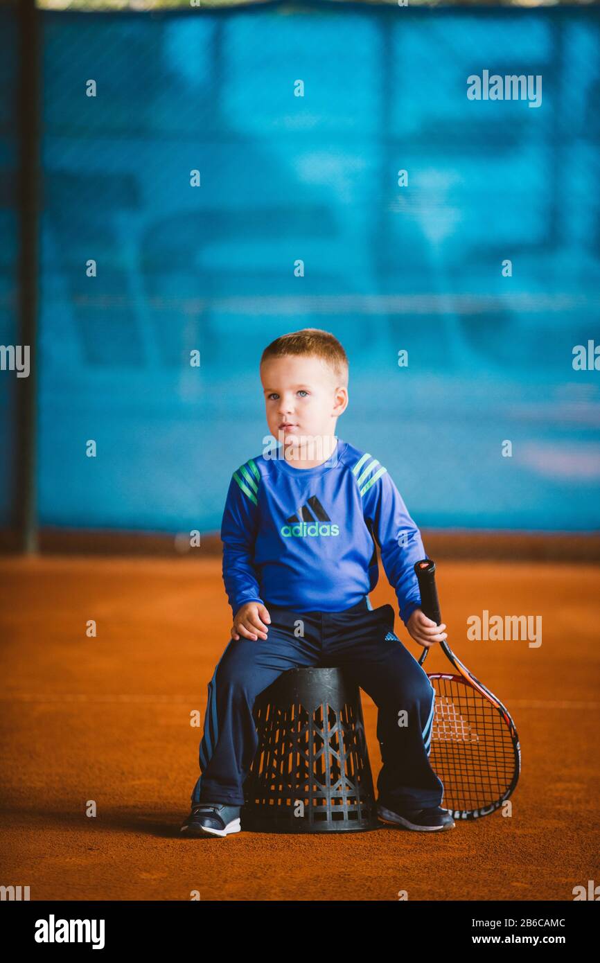 Niño jugando al tenis en la cancha al aire libre. 20 De Septiembre De 2016.  Ucrania, Kiev. Pequeño tenis, gran jugador. Niños ropa deportiva adidas.  Niño atleta Fotografía de stock - Alamy