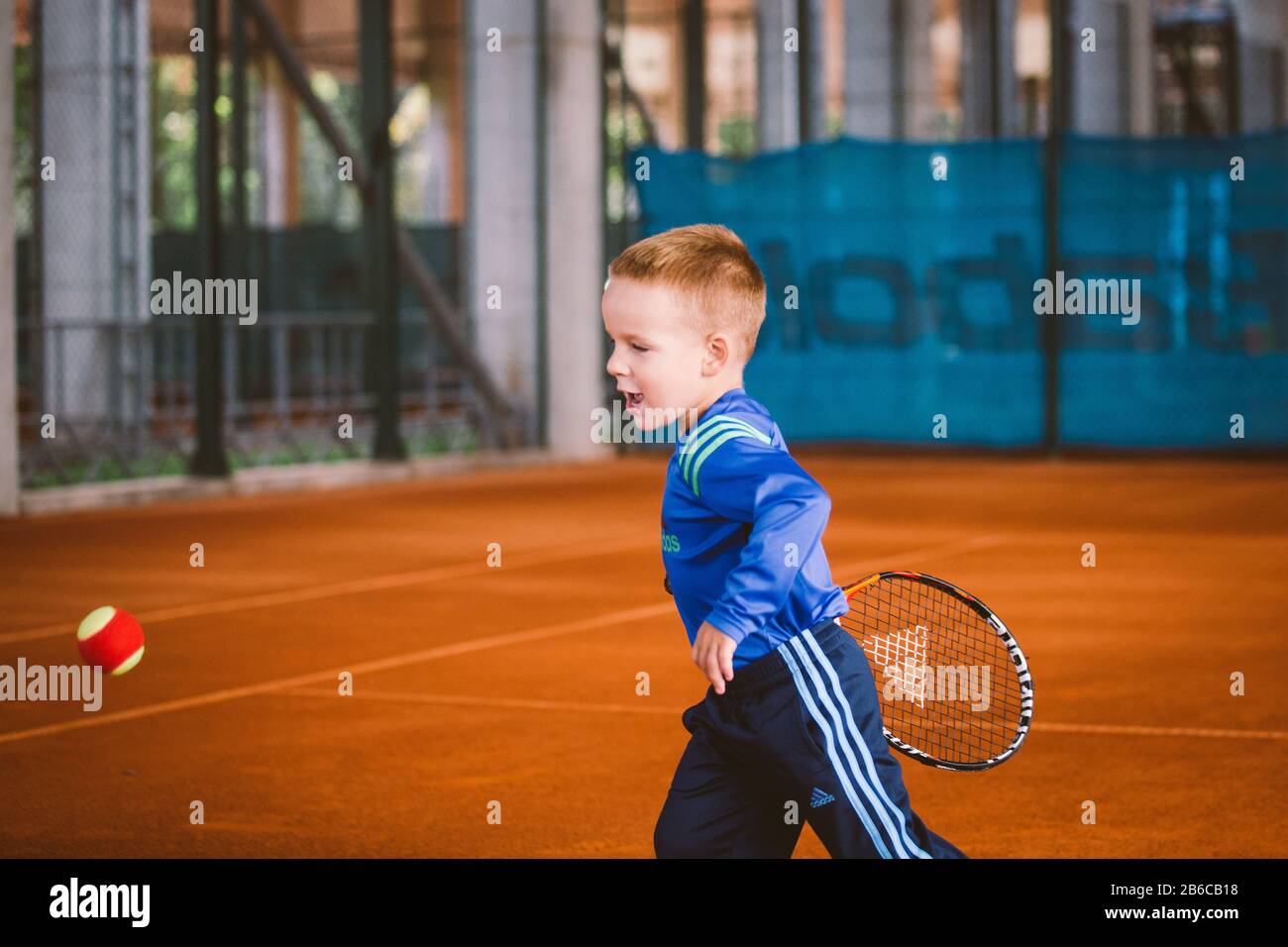 Niño jugando al tenis en la cancha al aire libre. 20 De Septiembre De 2016.  Ucrania, Kiev. Pequeño tenis, gran jugador. Niños ropa deportiva adidas.  Niño atleta Fotografía de stock - Alamy
