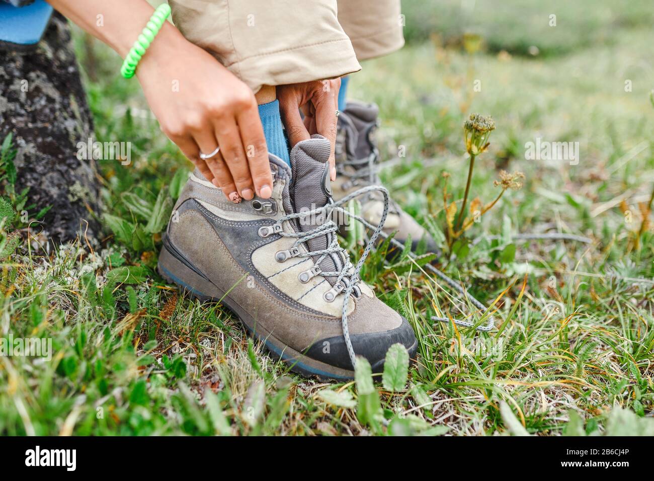 una mujer turística ata sus cordones en botas de trekking, concepto de  calzado al aire libre Fotografía de stock - Alamy