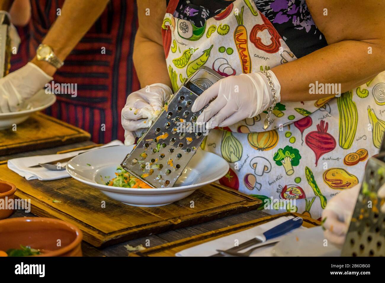 Los turis en clase de cocina aprenden a hacer zatziki zambullida Foto de stock
