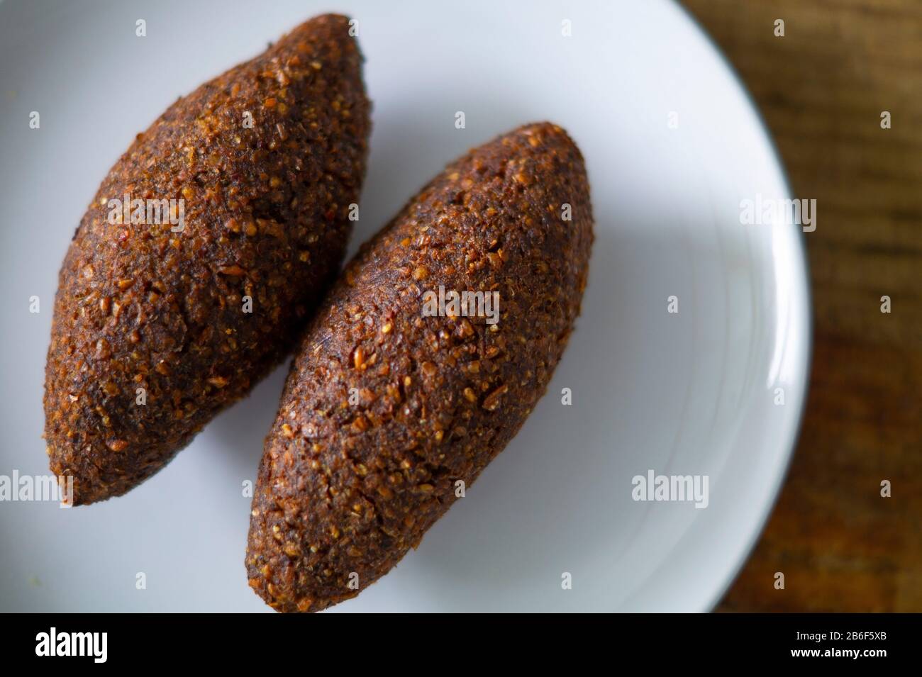 quipe, delicioso kibbeh frito con salsa de yogur en un bol visto en un  plato de arcilla sobre una vieja mesa de madera oscura, receta clásica,  vista Fotografía de stock - Alamy