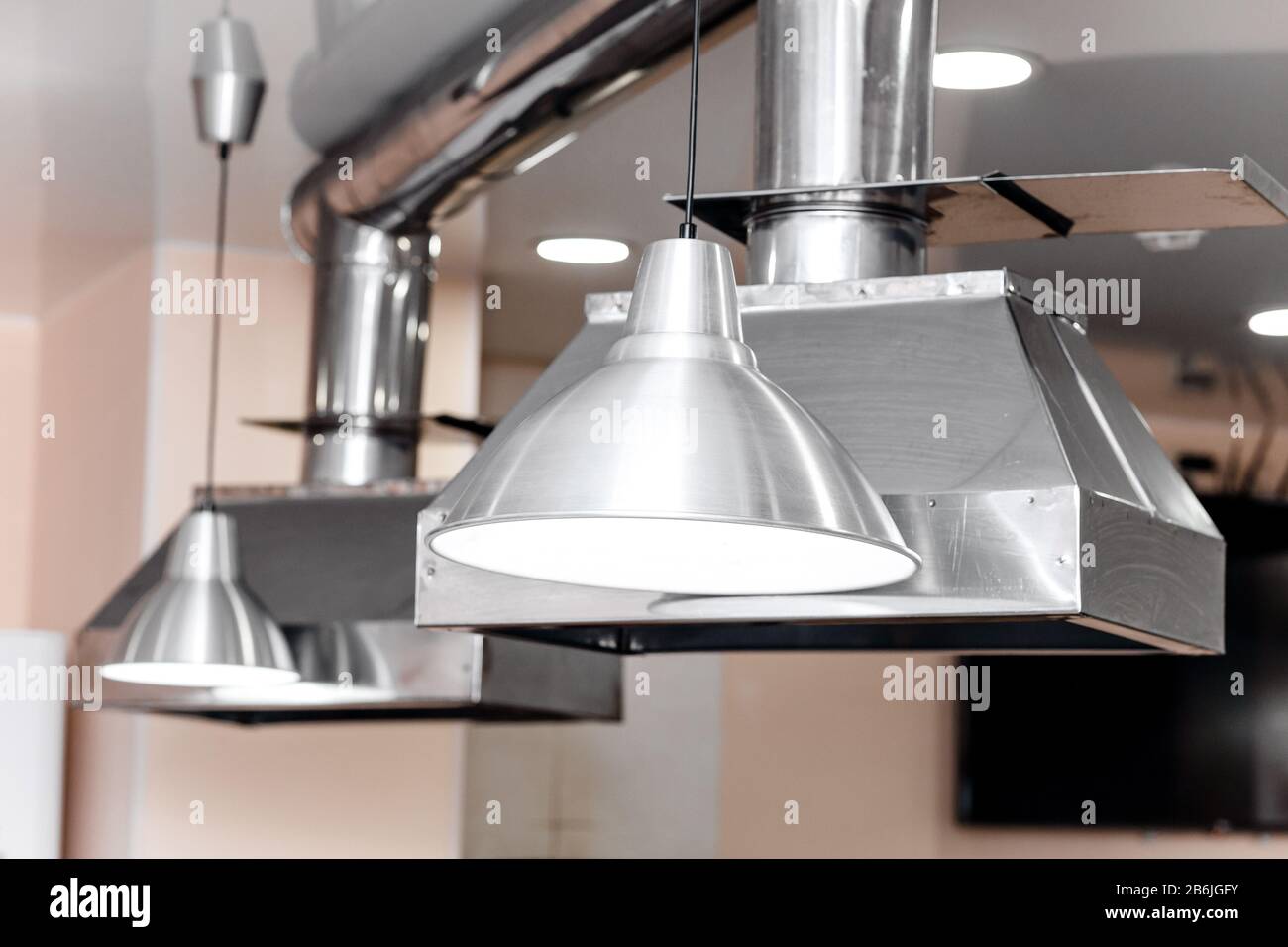 Elegante extractor de cocina de acero inoxidable en la sala de cocina del restaurante Foto de stock
