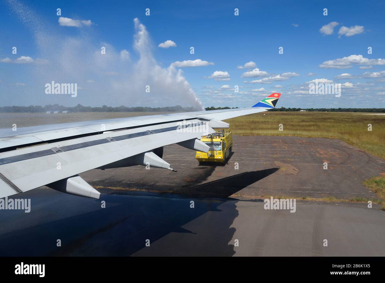 Saludo de canon del agua de la aviación después de la llegada al aeropuerto de Victoria Falls (VFA / FVFA) a bordo del Airbus A340 de South African Airways. Vista de ala desde el interior. Foto de stock