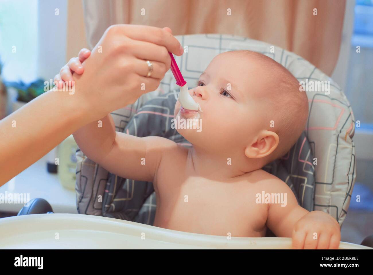 El bebé está comiendo su comida. Comida del bebé, fórmula, cuidado del bebé Foto de stock