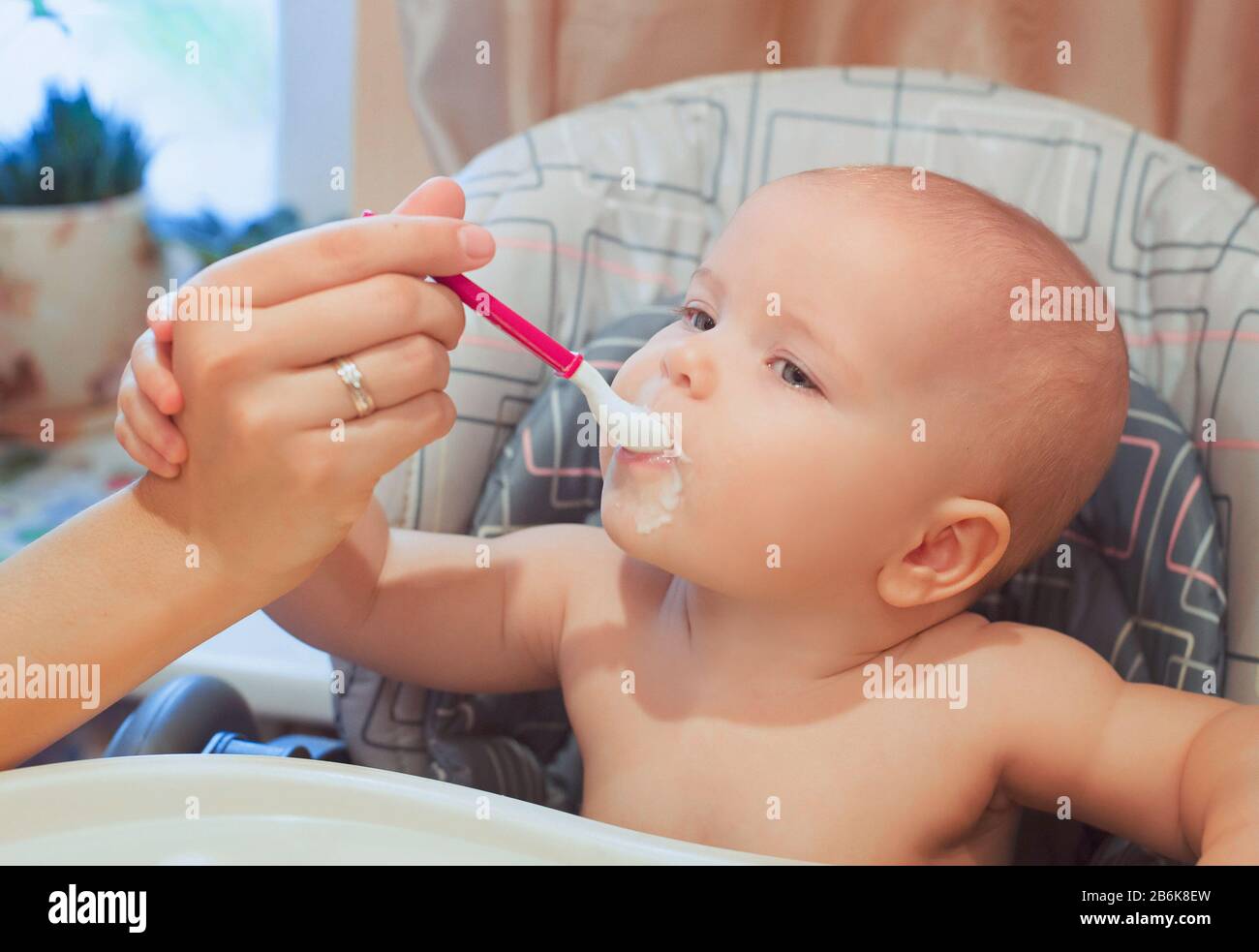 El bebé está comiendo su comida. Comida del bebé, fórmula, cuidado del bebé Foto de stock