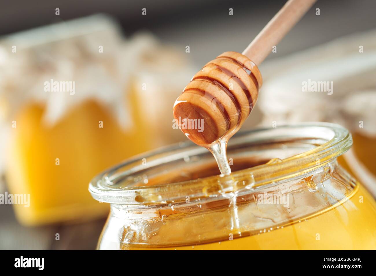Fondo de miel. Miel dulce en tarro de vidrio sobre fondo de madera. Foto de stock
