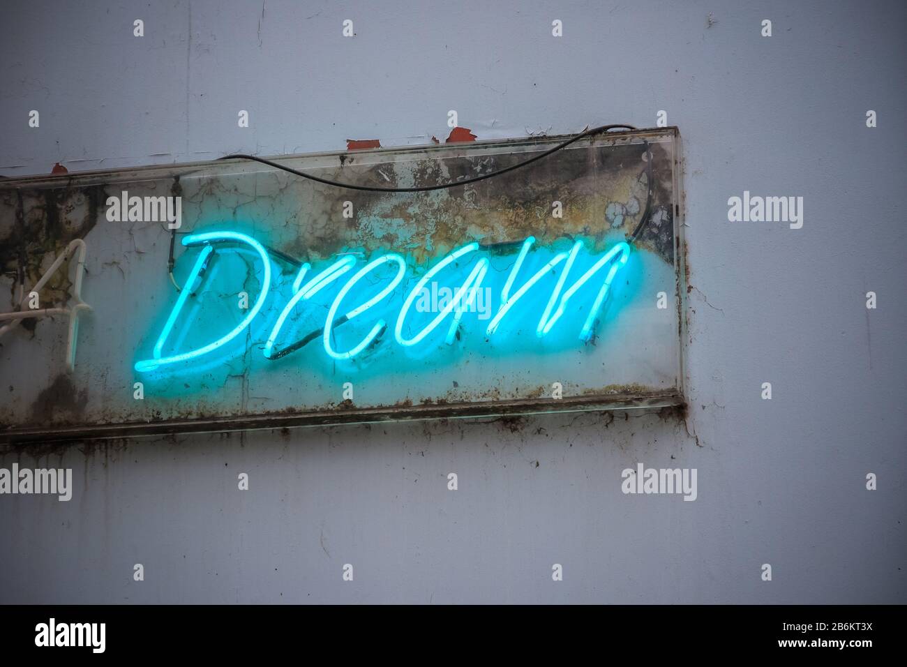 Cartel azul de neón Dream en una pared sucia de la calle de Londres Foto de stock