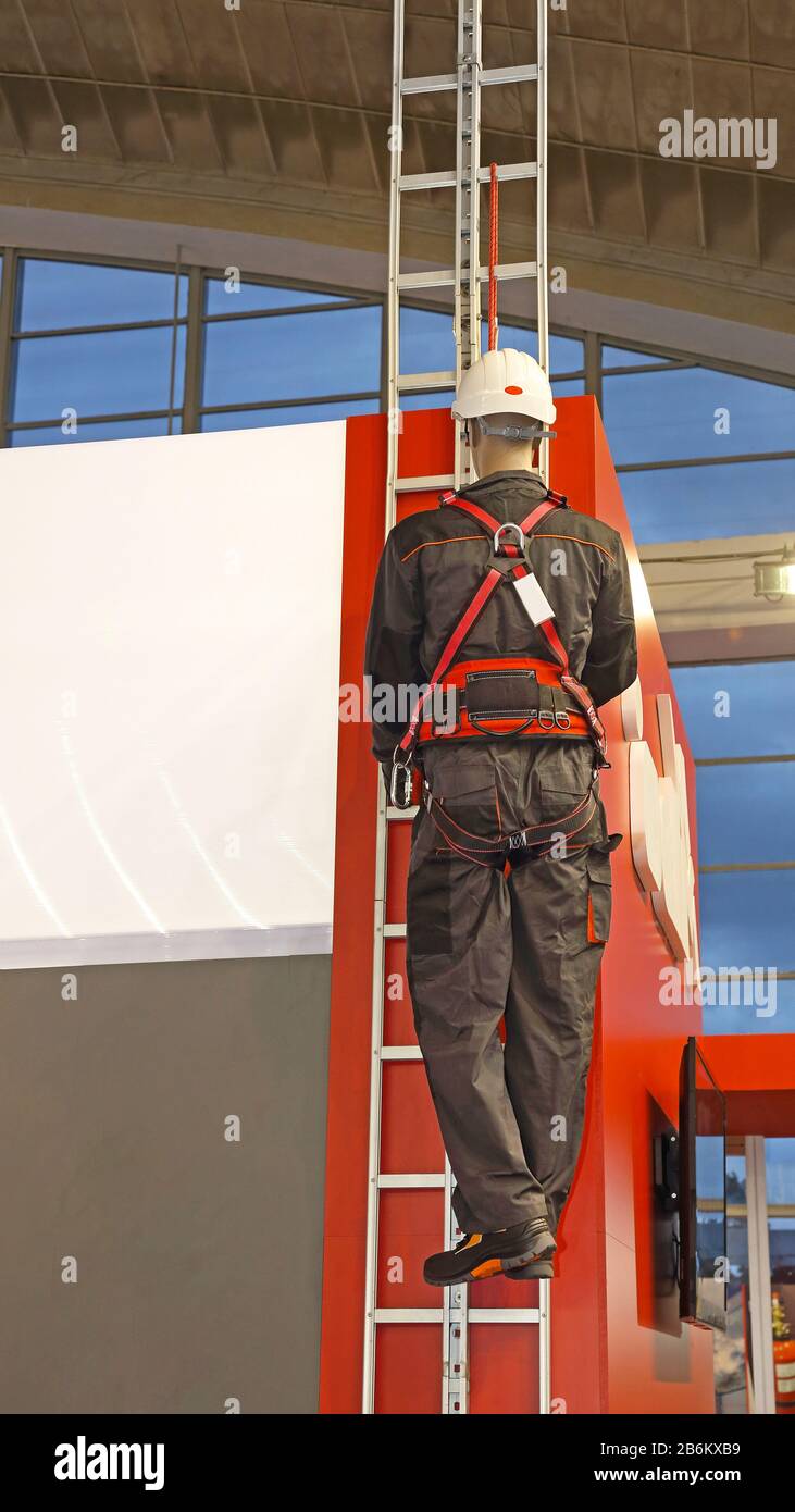 Trabajador En Una Escalera Con Protección De Arnés De Seguridad Fotografía  de stock - Alamy