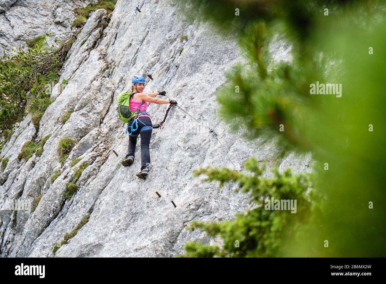 Mujer turística en un cruce en Intersport Klettersteig Donnerkogel por la ruta de ferrata, cerca de Gosau, en Austria. Foto de stock