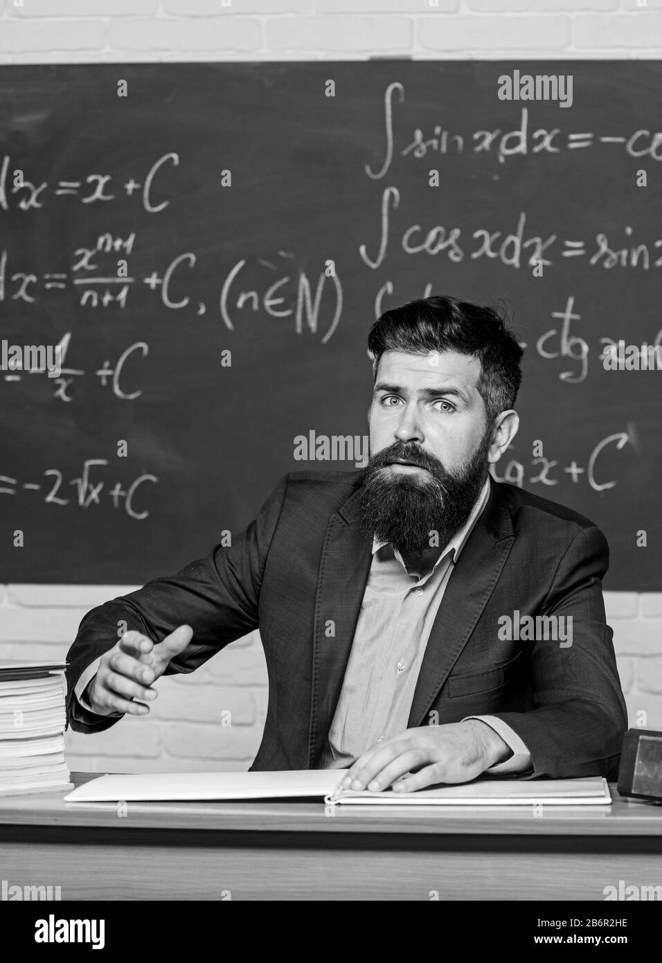 Profesor exigente. Salir de la clase. Maestro estricto hombre barbado graves antecedentes de la pizarra. Profesor miradas amenazantes. Normas de buena conducta. El director de la escuela amenazan con el castigo. Foto de stock