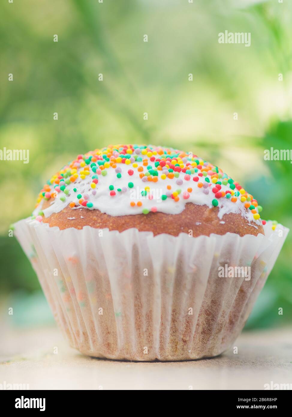Pequeño cupcake de pascua envuelto en un muffin blanco. Comida de vacaciones en el jardín. Foto de stock