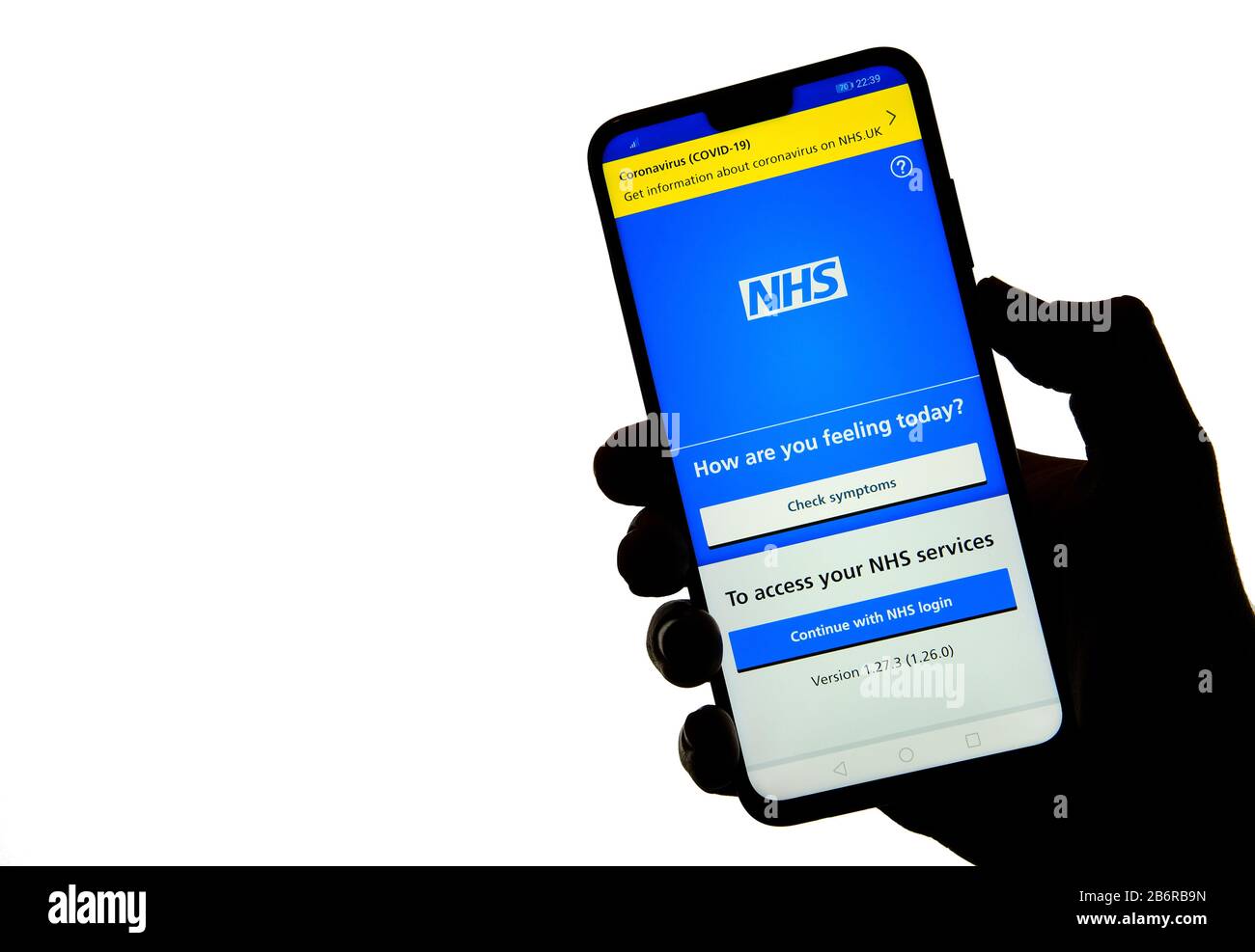 Stone / Reino Unido - Marzo de 11 2020: Aplicación NHS sobre la silueta de un smartphone en la mano. Foto de stock