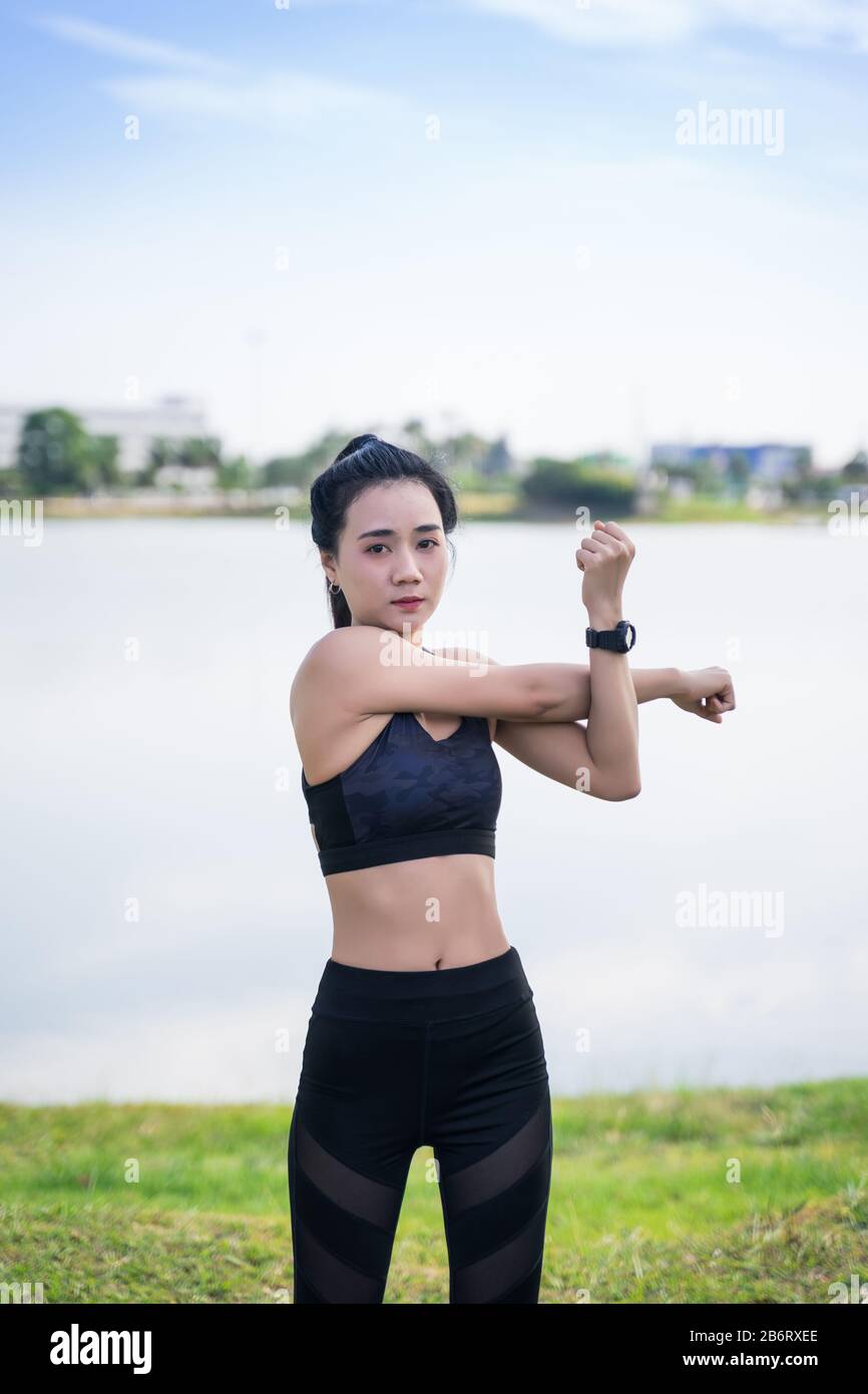 Mujer asiática con ropa deportiva haciendo estiramientos antes de