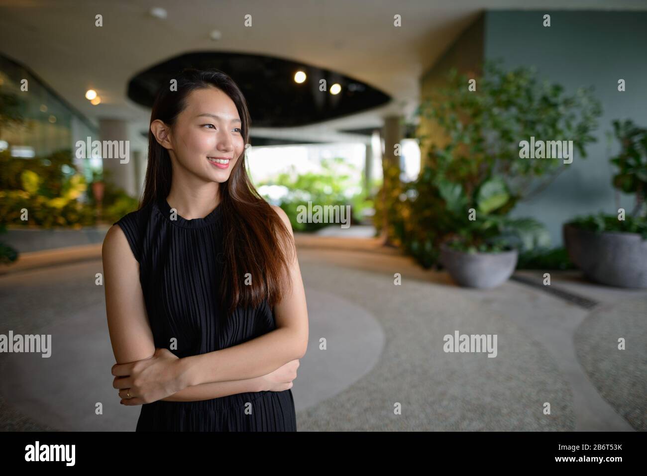 Feliz joven hermosa empresaria asiática pensando en el jardín interior Foto de stock