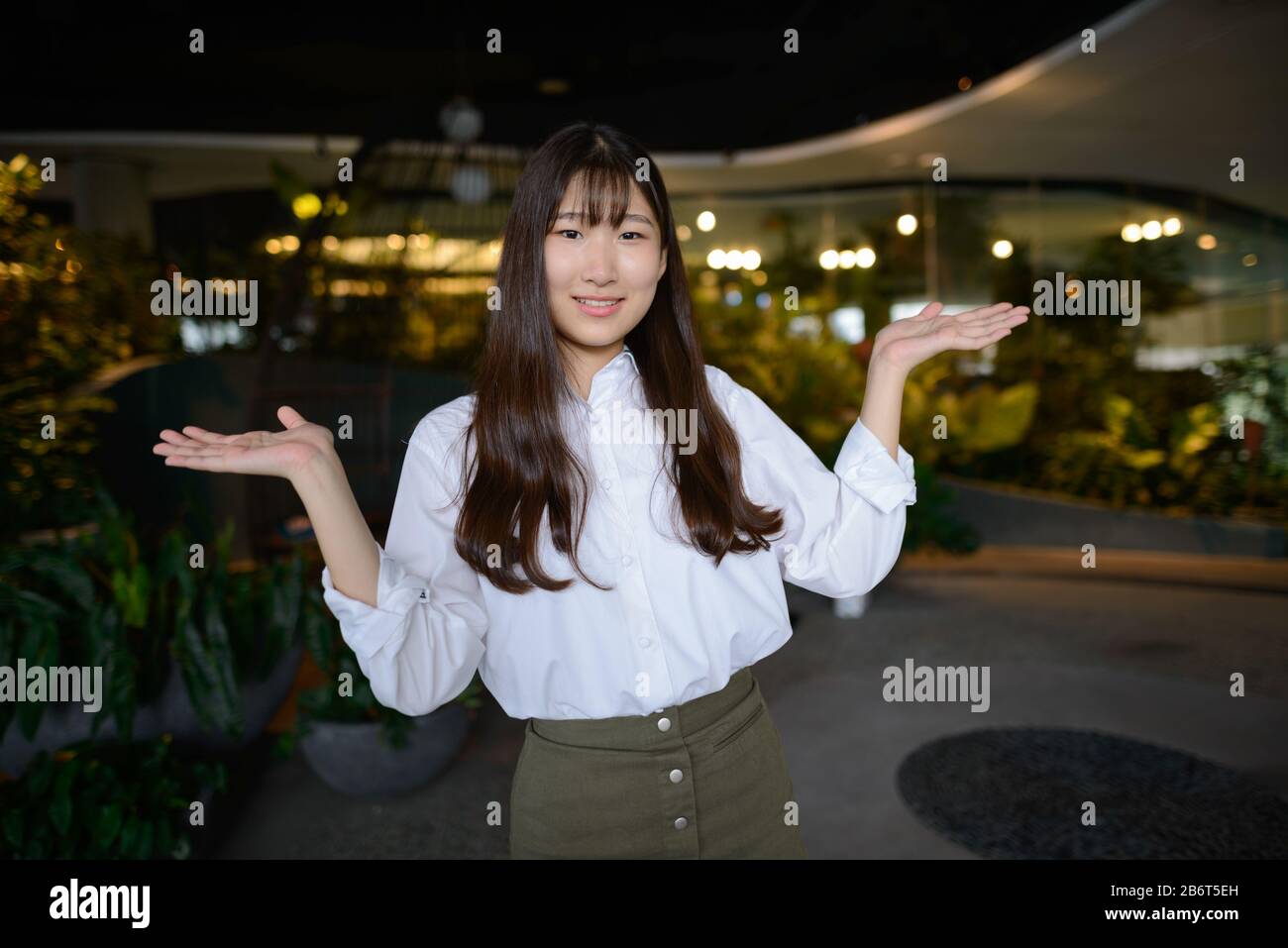 Feliz joven hermosa adolescente asiática en el jardín interior Foto de stock