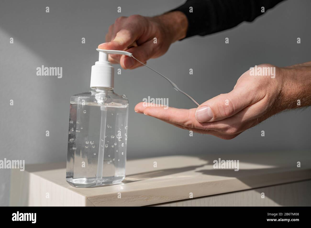 Desinfectante de manos gel de alcohol frotar manos limpias higiene prevención del brote del virus coronavirus. Hombre usando una botella de jabón desinfectante antibacteriano. Foto de stock