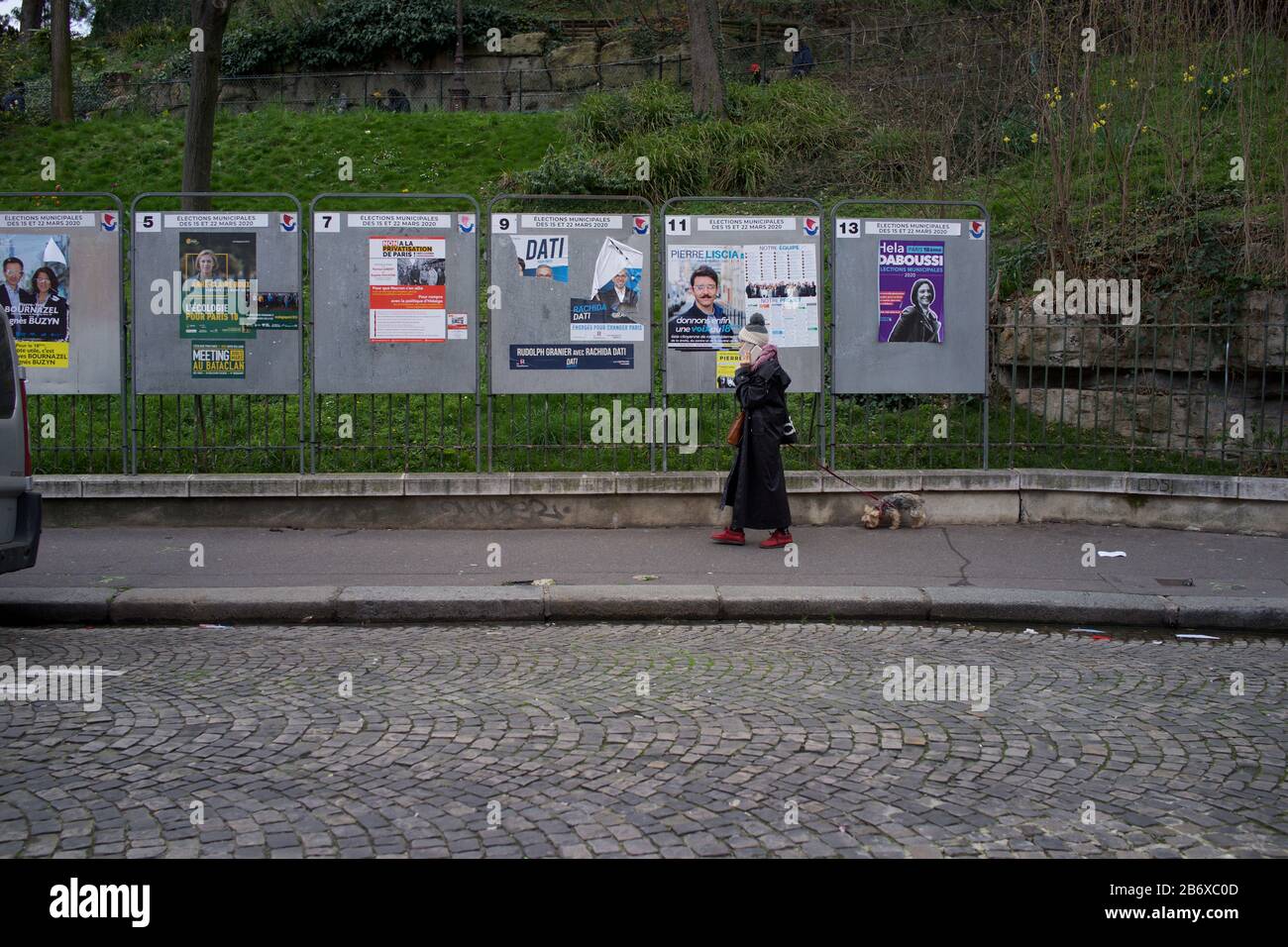 La mujer pasa por paneles de exhibición que muestran candidatos electorales que se presentan en las elecciones municipales francesas, rue Ronsard, Montmartre, 75018 París, Francia, marzo de 2020 Foto de stock