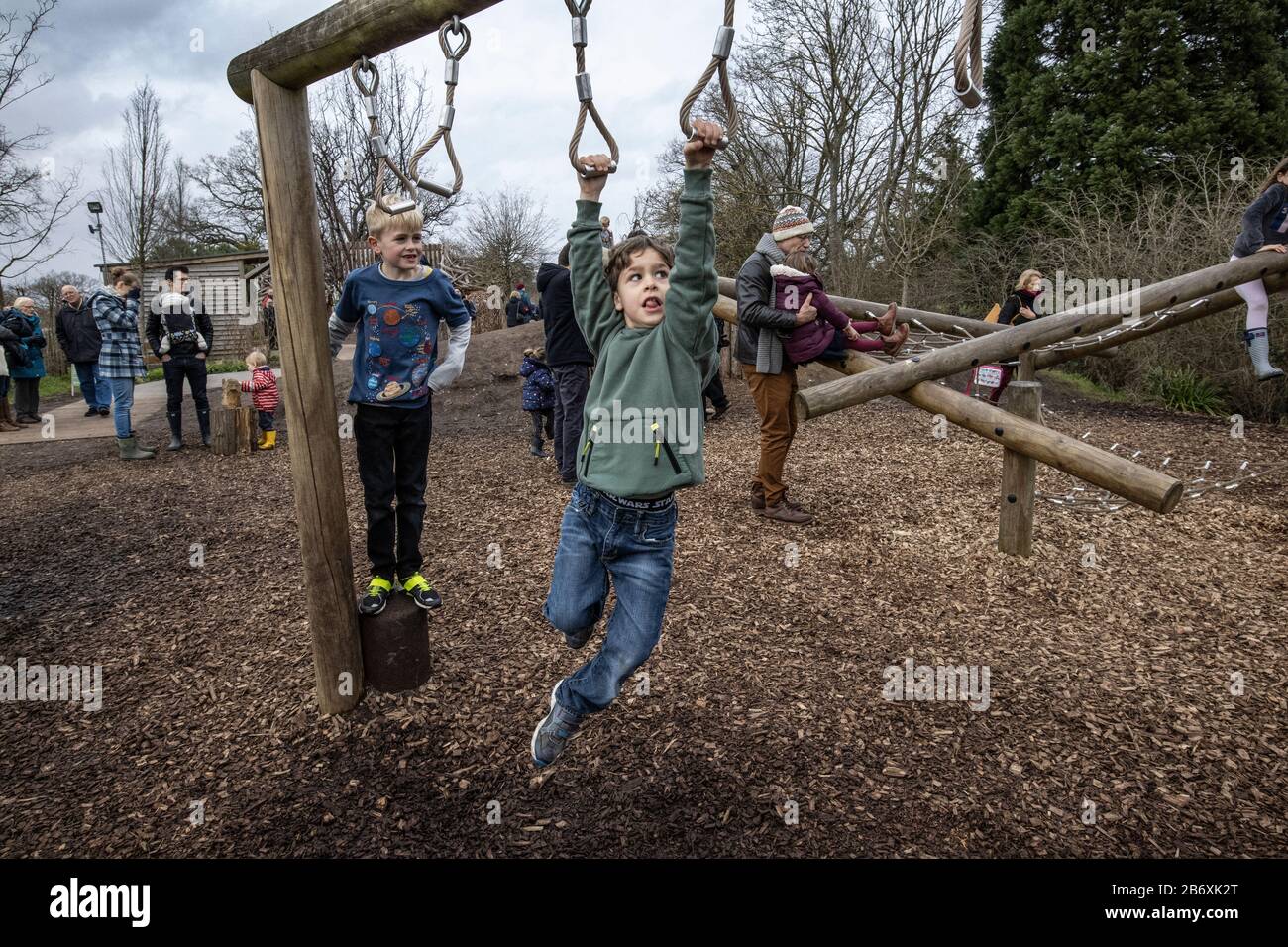 Niños activos que suben en el RHS Volver a la zona de actividades al aire libre de Nature Garden en RHS Wisley co-diseñado por La Duquesa de Cambridge, Surrey, Inglaterra, Reino Unido Foto de stock