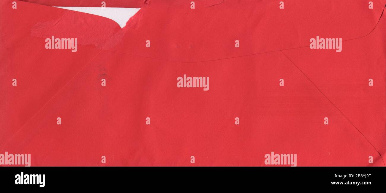 Escaneo de alta resolución de un sobre viejo de color rojo con una inserción de papel de color blanco. El papel está roto y teñido. Foto de stock