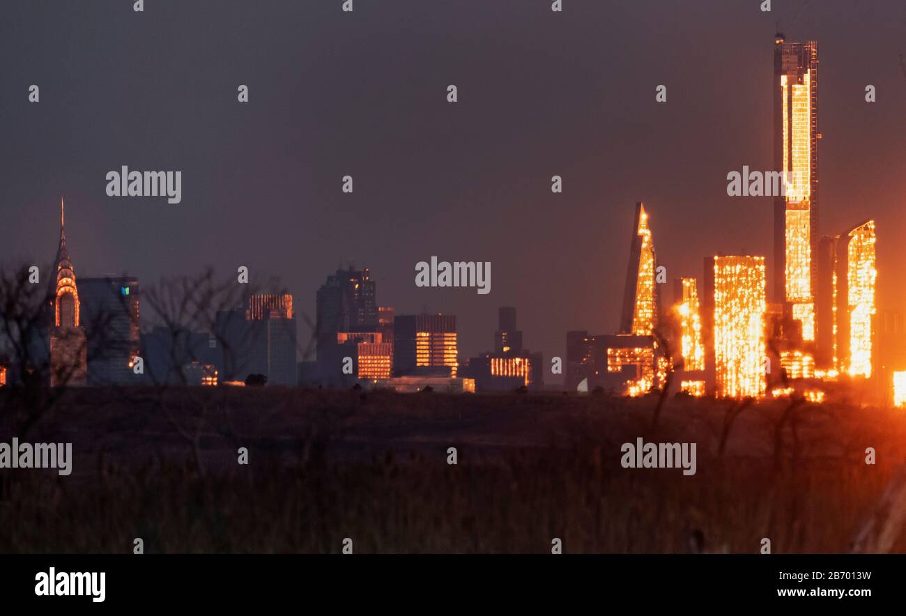 El horizonte urbano de la ciudad de Nueva York está iluminado de forma brillante al amanecer Foto de stock