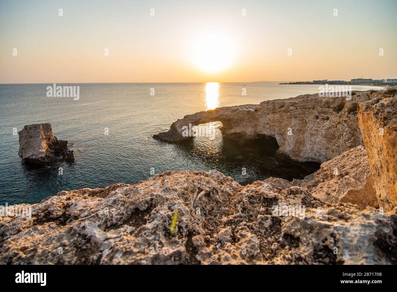 Hermosa puesta de sol en el puente de piedra natural cerca de Ayia Napa en Chipre. Puente del amor. Cavo greco Foto de stock