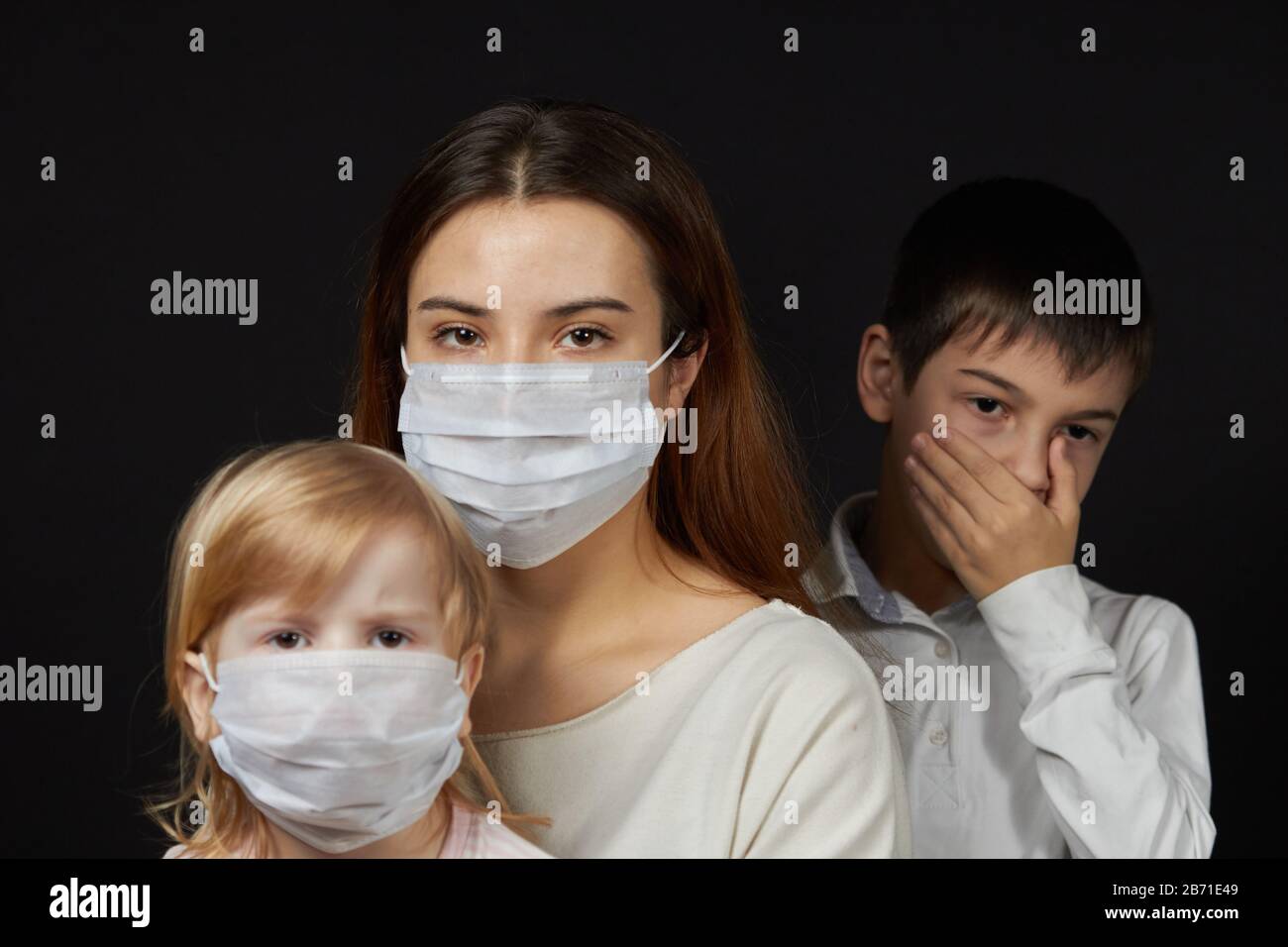 estornudos enmascarados de niña y niño, el concepto de protección contra la propagación de la máscara médica del virus. Foto de stock