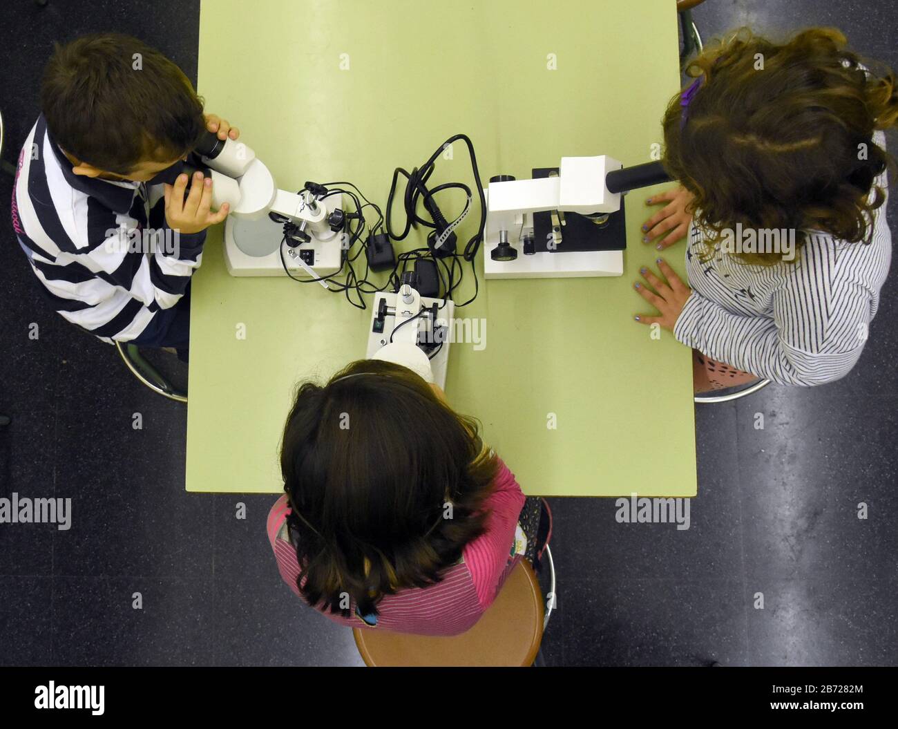 Barcelona, España. 12 de marzo de 2020. Los niños observan con microscopios  en una clase de ciencia en una escuela de Barcelona.Debido al brote del  virus Corona COVID-19, la Generalitat de Cataluña
