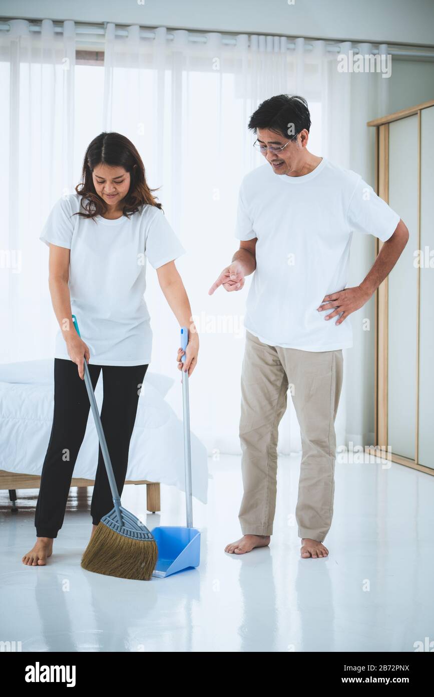 Pareja disfrutando de la limpieza de su casa con aspiradora y fregona  Fotografía de stock - Alamy