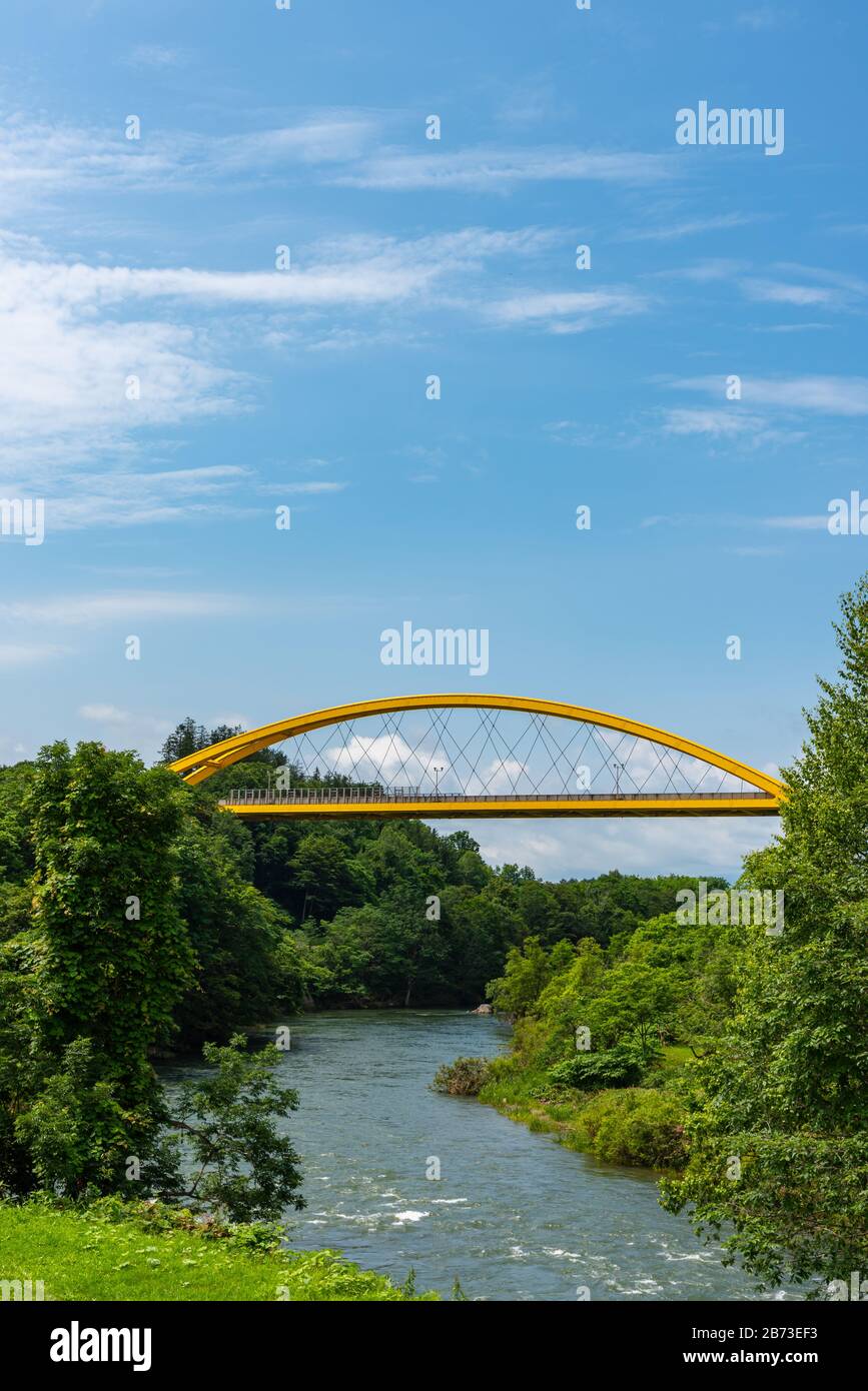 Puente de Niseko en la primavera, un puente amarillo que atraviesa la línea principal de Hakodate y el río Shiribetsu Foto de stock