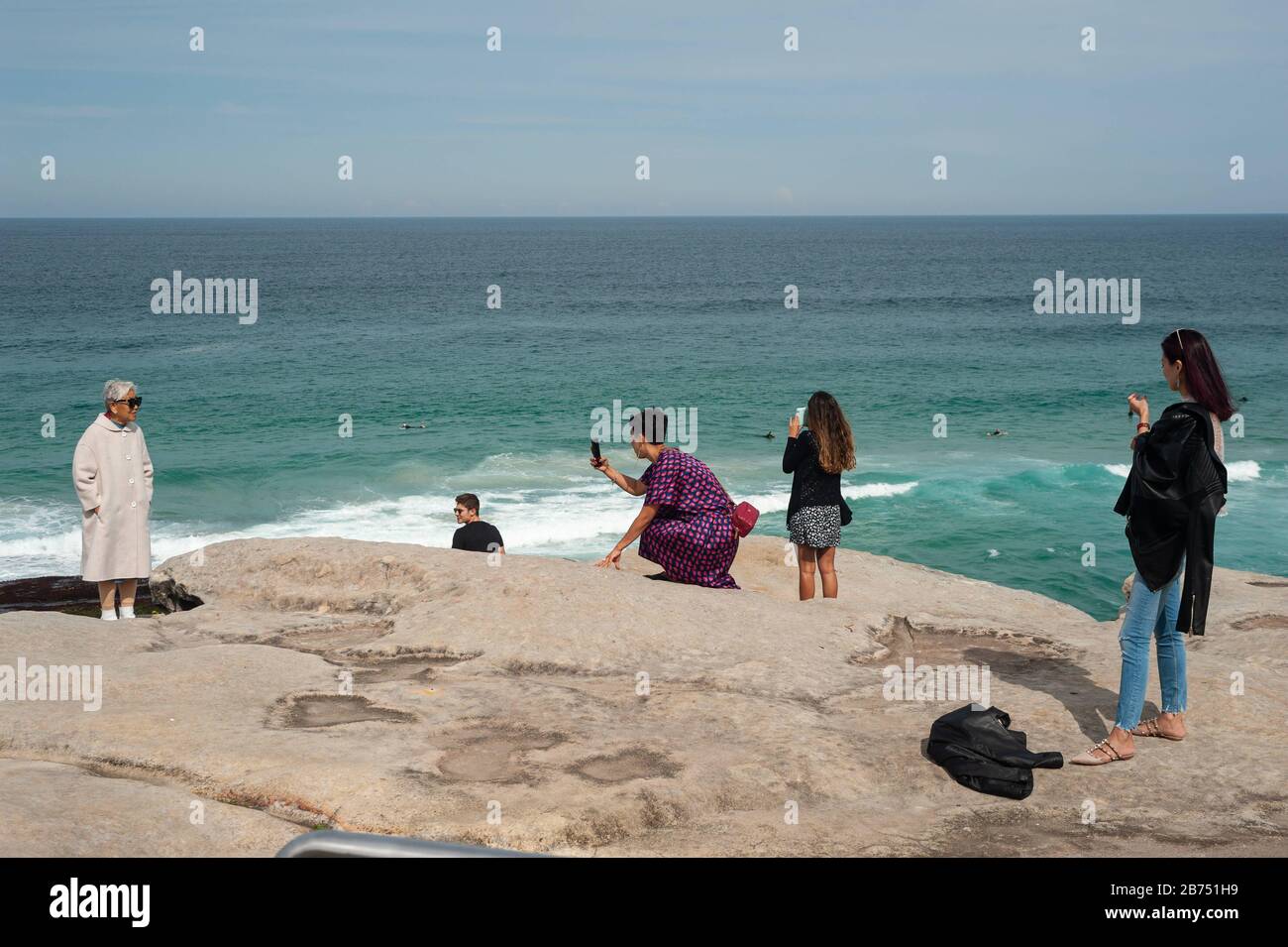 27.09.2019, Sydney, Nueva Gales del Sur, Australia - los turistas toman fotos en los acantilados de Tamarama Point con una vista del mar. El mirador está situado en la ruta costera Bondi a Coogee Walk. [traducción automática] Foto de stock