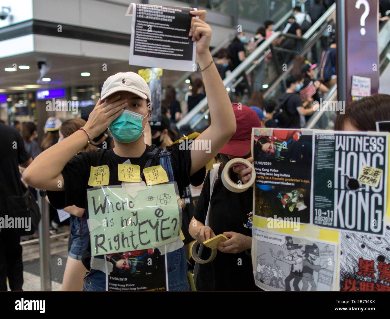 Miles de personas anti-gobierno ocupan el Aeropuerto Internacional de Hong Kong en Hong Kong. Estaban furiosos con un policía que disparó a la vista derecha de una enfermera que causó una ceguera permanente durante su enfrentamiento anoche en Tsim Sha Tsui. Todos los vuelos se cancelaron a última hora de la tarde. Foto de stock