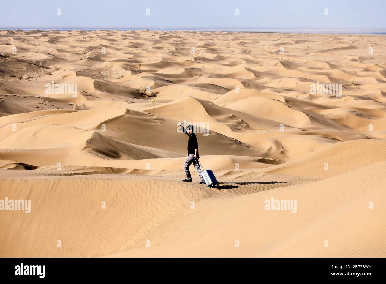 Imagen simbólica: Turista con maleta en el desierto, Desierto de Mesr,  Irán. El desierto de Mesr es parte del desierto central en Irán. [traducción  automática] Fotografía de stock - Alamy